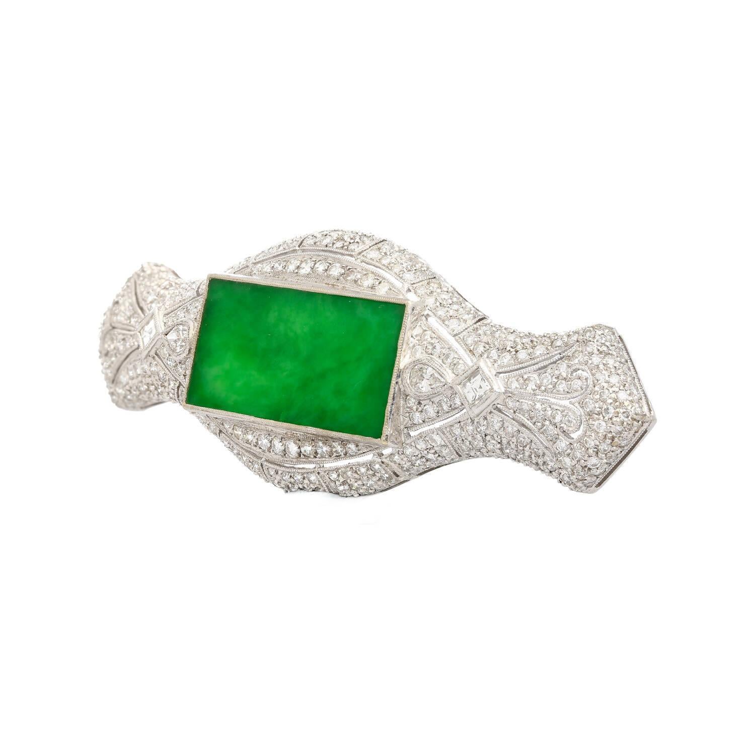 Jewelry Details:
Item Type: Brooch Pin
Metal Type: 18K White Gold
Weight: 16.9 grams
Length: 2.75 Inches

Center Stone Details:
Gemstone: Jadeite Jade
Dimensions: Approximately 2.5 x 6 cm

Side Stone Details:
Diamonds:2 Pear-Shaped Diamonds
2