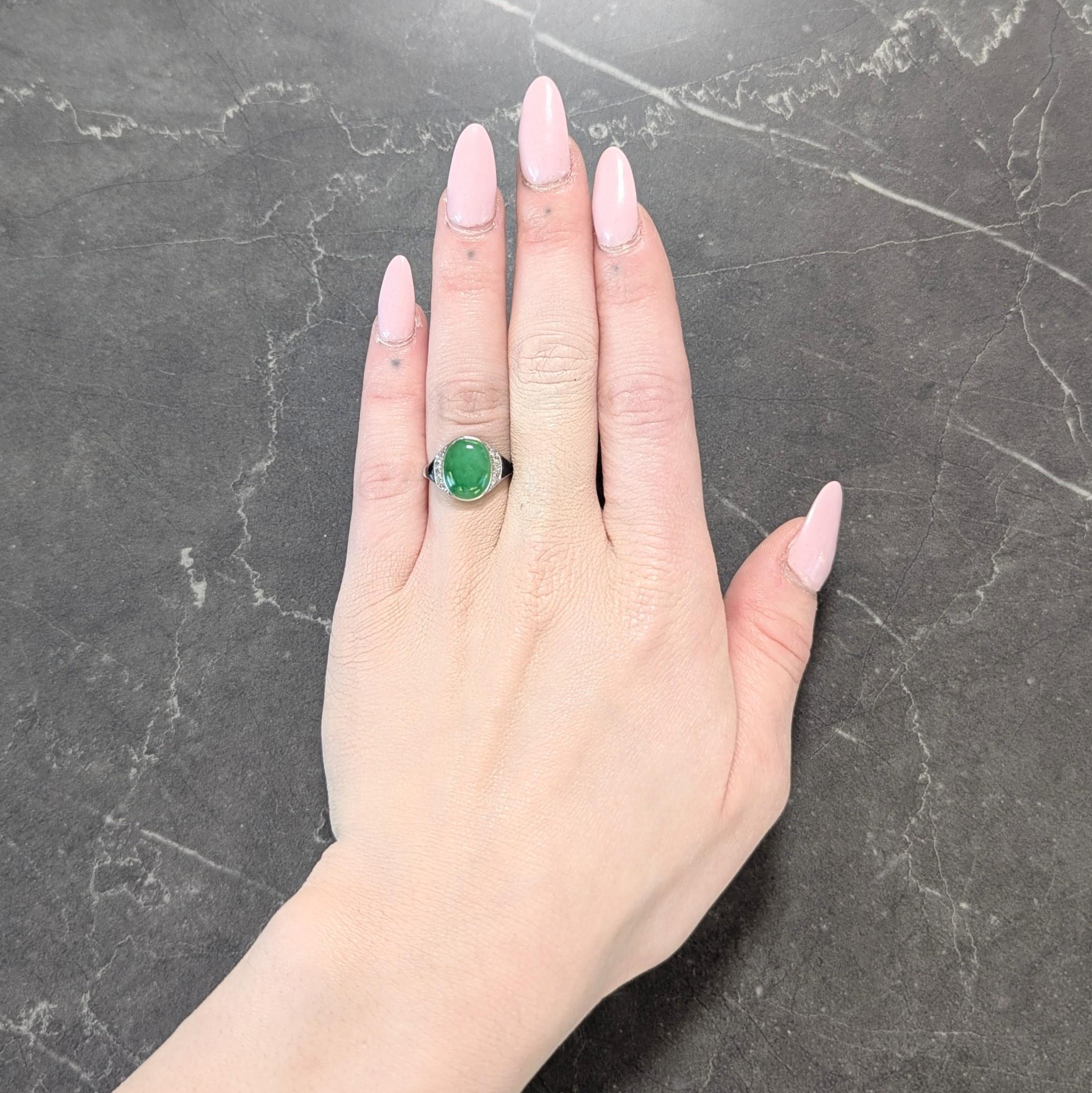 Centering an oval shaped jade cabochon measuring 9.0 x 11.0 mm
Translucent vibrant green in color with subtle mottling - bezel set
Flanked by rows of bead set single cut diamonds
Weighing approximately 0.16 carat total - eye clean and