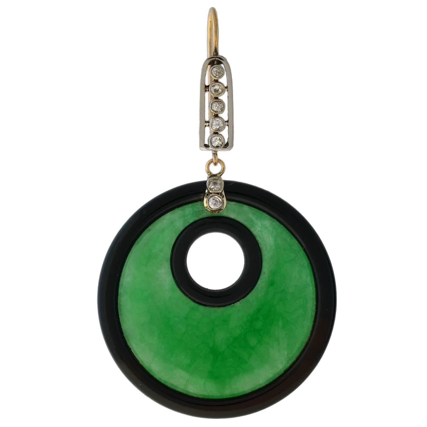 An impressive pair of statement earrings from the Art Deco (ca1930) era! Each earring features a large jadeite hoop at the base, which is hugged by two rings of black onyx, forming an inner and outer border. In person, the jadeite displays a