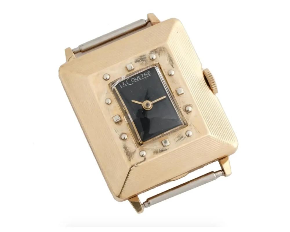 An antique 1920s 14K yellow gold wristwatch case by Jaeger LeCoultre. Art Deco geometrical design, stepped rectangular bezel with single crown. Small black rectangular dial, round numerals, marked LeCoultre. Marked L, 14K on the backside. Total