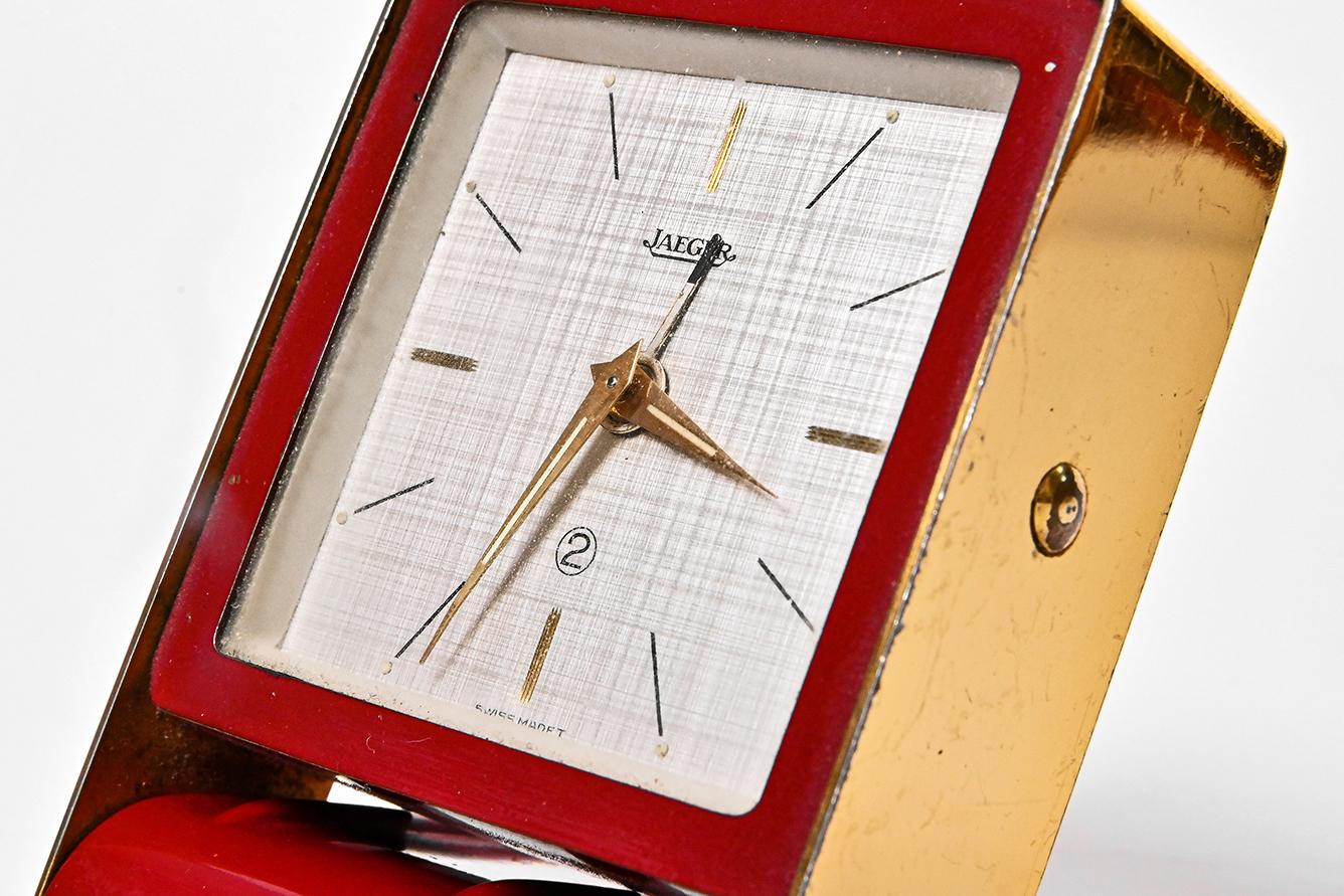 Art Deco Jaeger-LeCoultre travel alarm clock Burgundy colored

Jaeger-LeCoultre travel alarm clock from circa 1960, with burgundy painted folding. The dial is textured with golden colored clock-arms. It’s mechanical movement is designed to 2 days