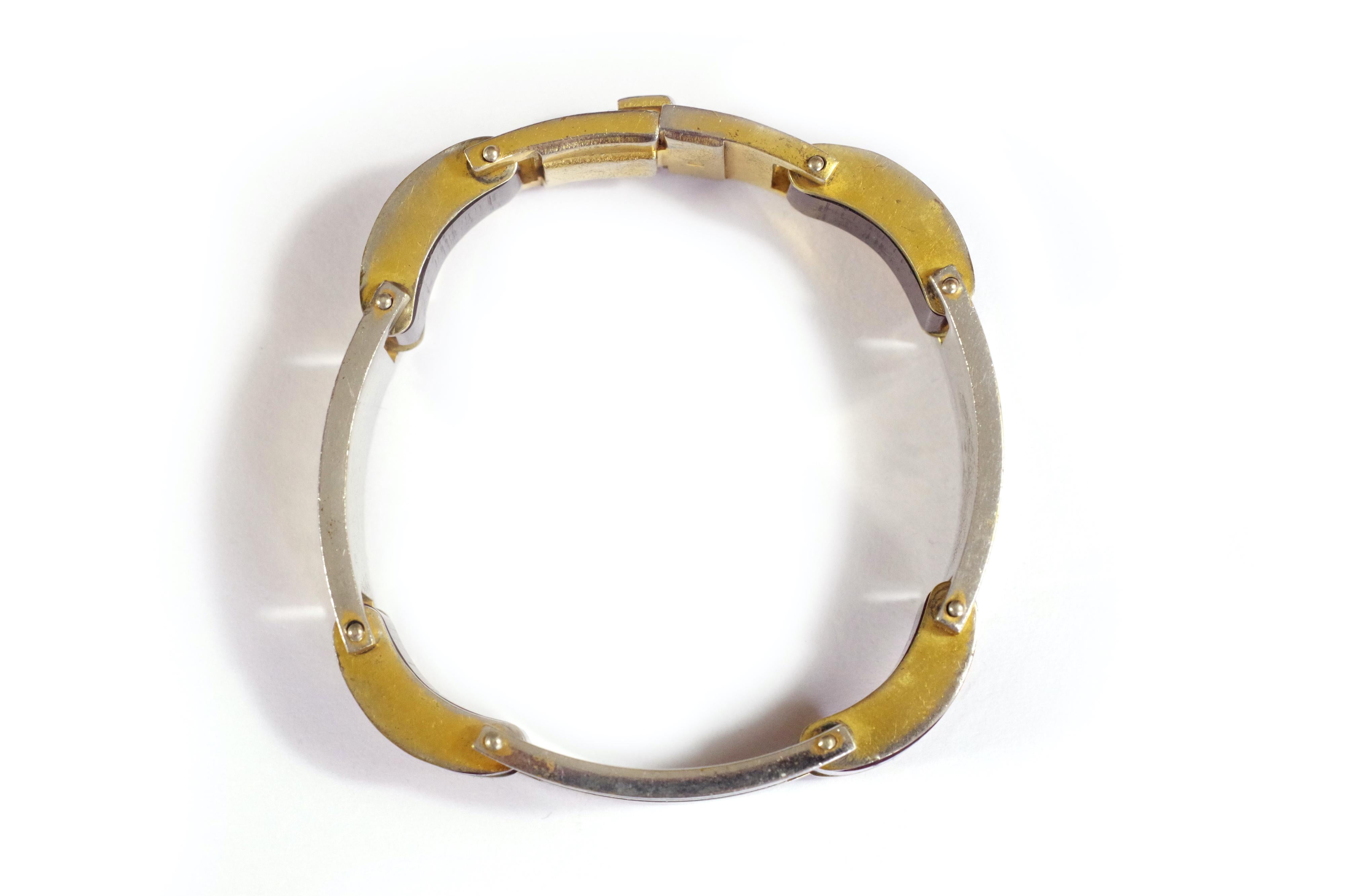 Art Deco Jakob Bengel Armband aus verchromtem Metall. Geometrisches Armband mit rechteckigen Gliedern mit wechselnden Mustern. Einige mit geometrischen Linien in silber- und goldverchromtem Metall, die anderen Glieder in braunem Galathit und