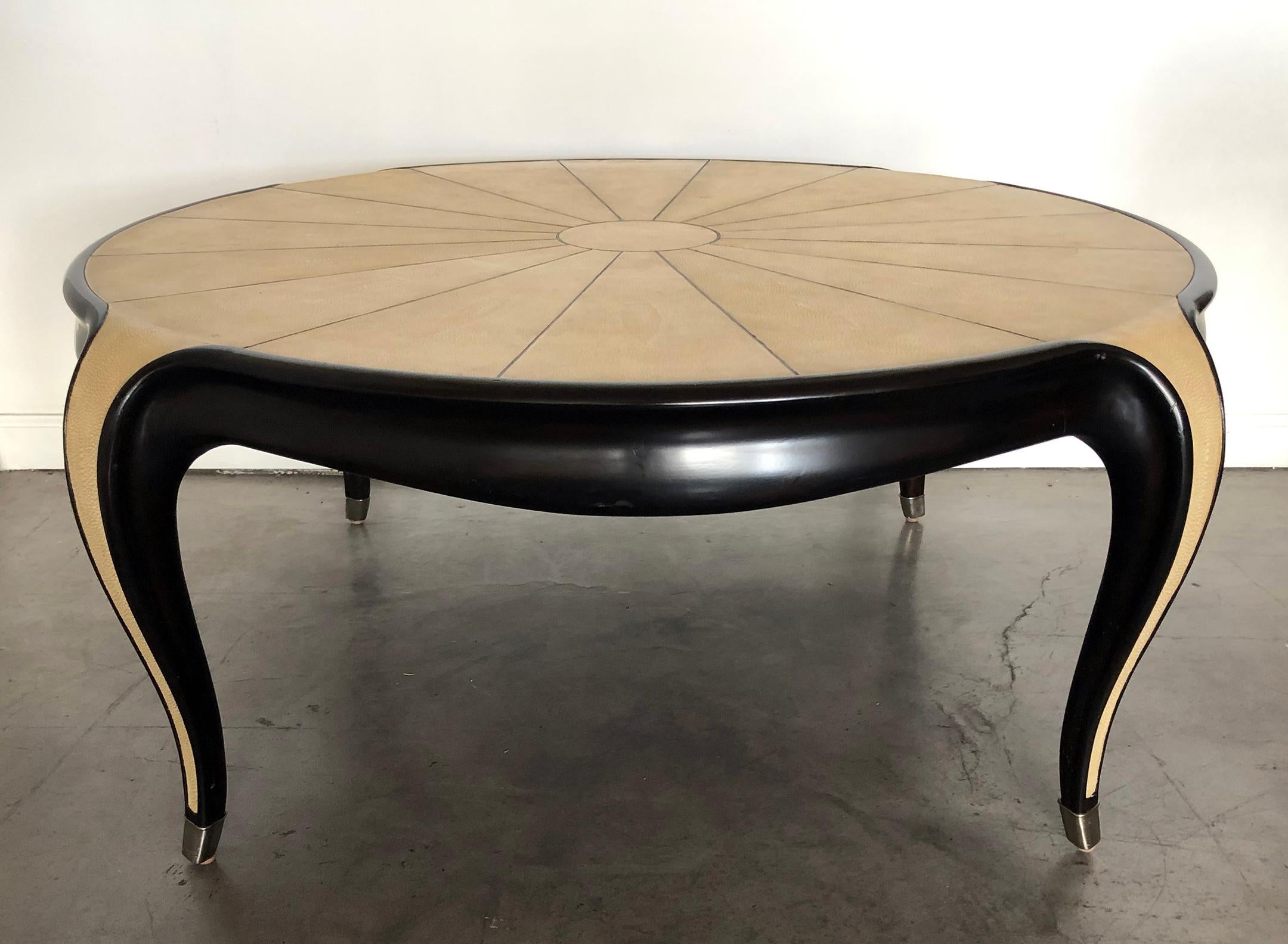 Beautiful Jallot Style Art Deco inspired faux shagreen coffee / cocktail table with ebonized wood legs and brass caps. The coffee table rests on four sabot shaped and brass tipped carved cabriole legs with shagreen inlay featuring a sunburst motif