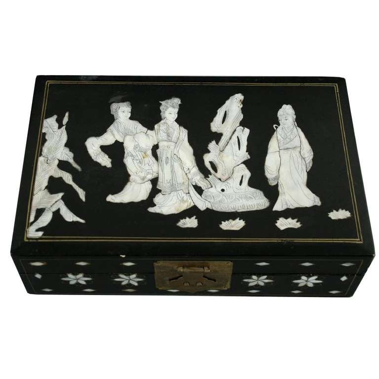 Art Deco Japanese Decor jewelry box black Lacquer and mother of pearl.
Jewelry box, black lacquered, rectangular shape with hinged lid, with black engraved mother of pearl inlay on the lid, three young women and a large stone-monument.
On the sides