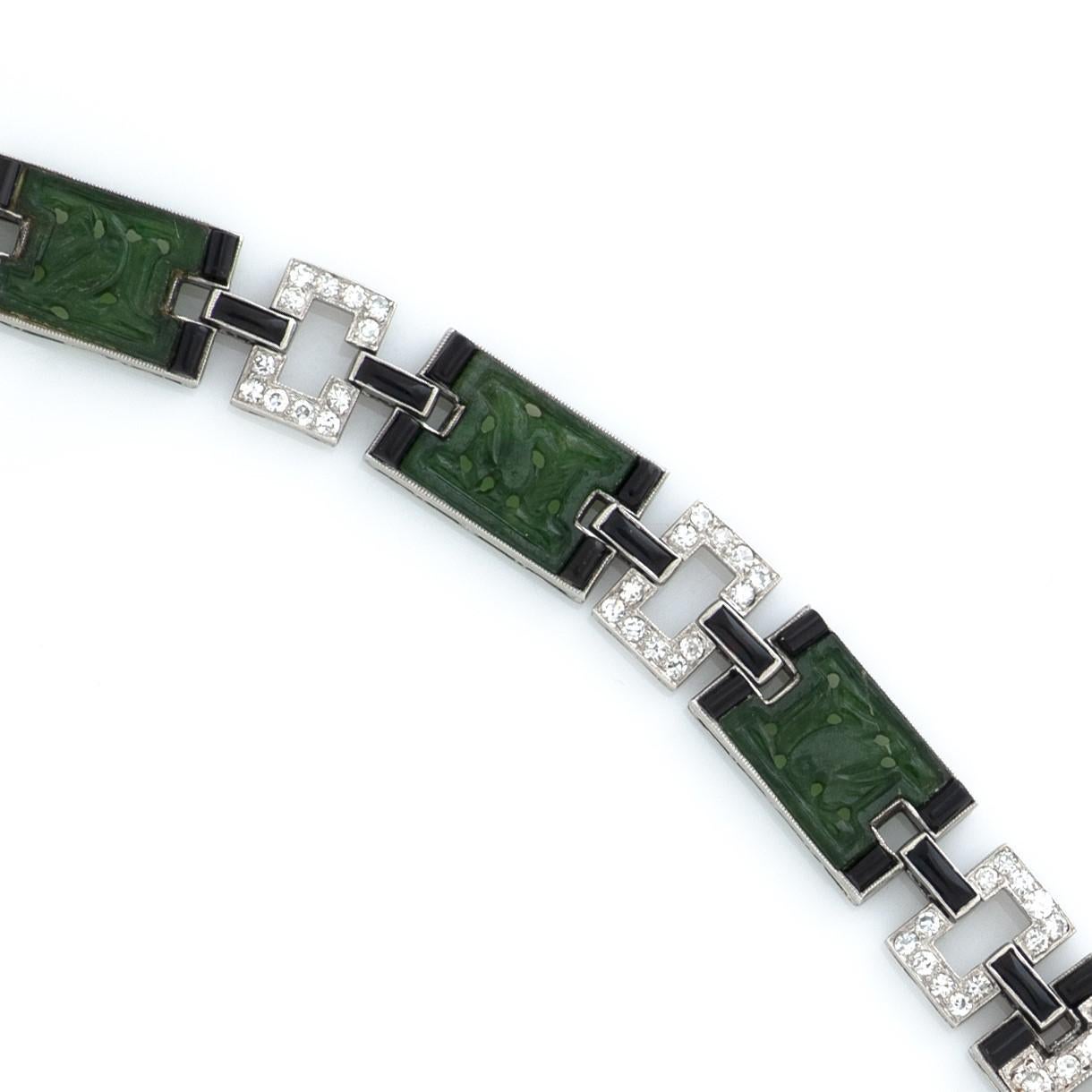 Ce modèle Art déco J.E. Le bracelet en platine de Caldwell & Co. présente 6 motifs en jade sculpté séparés par des liens en diamant et en onyx.  Les maillons contiennent environ 1,95 carat de diamants taille unique de couleur G-I et de pureté