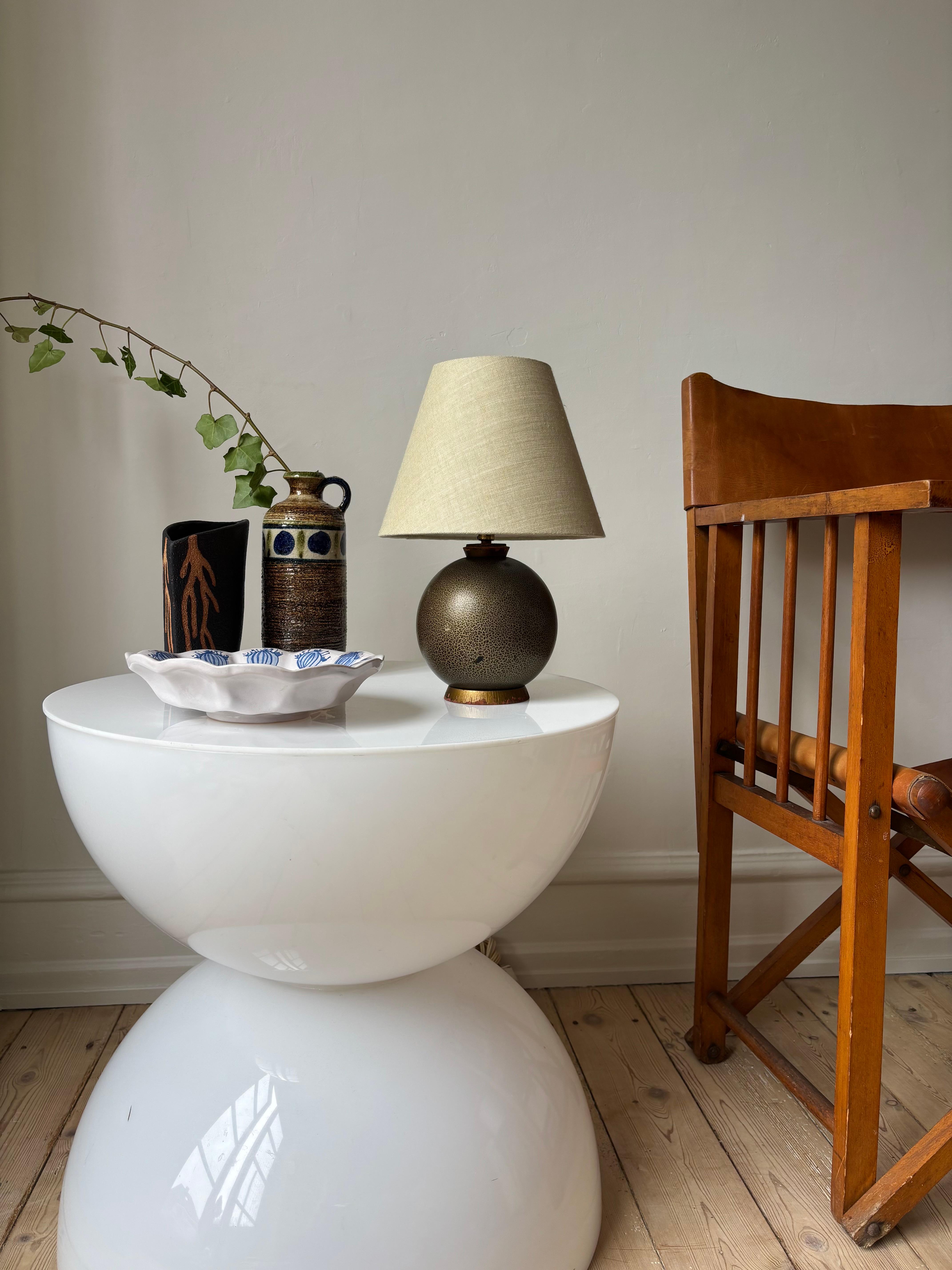 Small spherical antique wooden table light in the style of Jean Besnard. Beautifully lacquered in earthy olive green, brown and golden colors in animalistic speckled pattern. Wooden top and base with golden paint. Created by anonymous designer