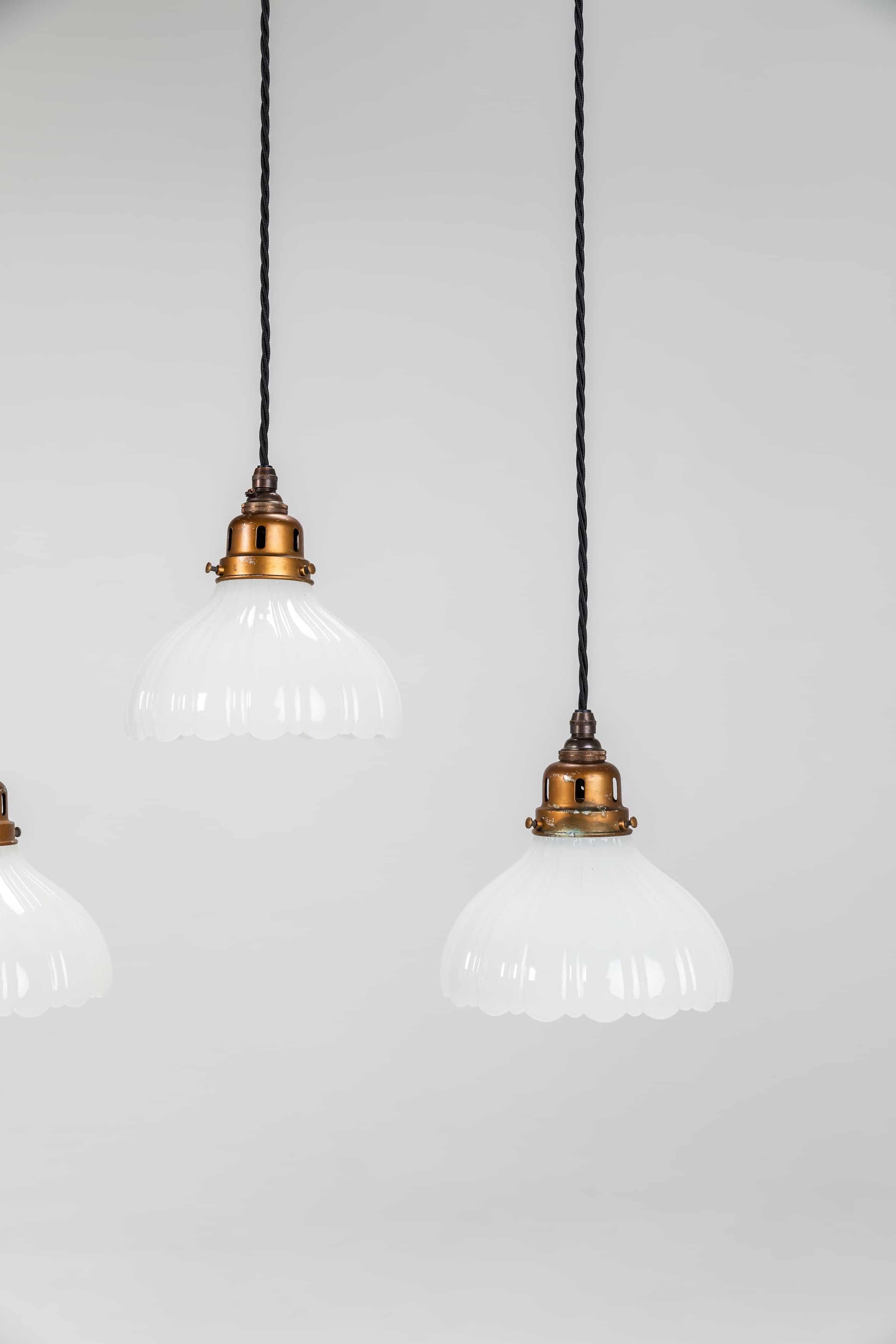 A beautiful run of heavy duty Jefferson Moonstone glass pendant lights. c.1920

Excellent quality lamps with thick pressed opaque fluted glass shades and faux bronze galleries. Price is per lamp.

Rewired with 1m of black twist flex.