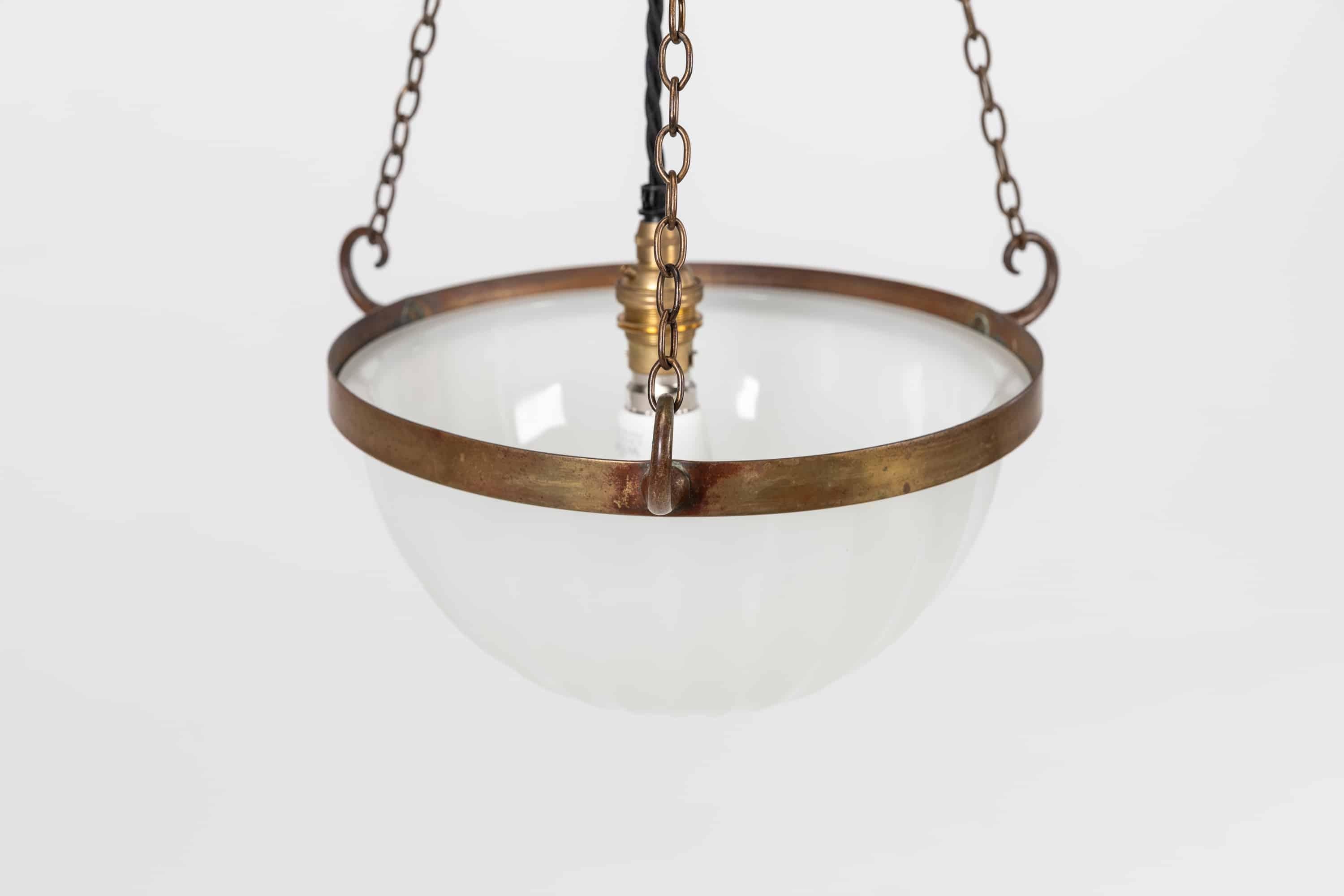 A beautifully formed 12” pressed glass Jefferson 'Moonstone' plafonnier. c.1930

Heavy duty pressed milk glass of fluted design set in a simple brass ring with three monkey tail hooks and chain.

Rewired with black twisted flex.