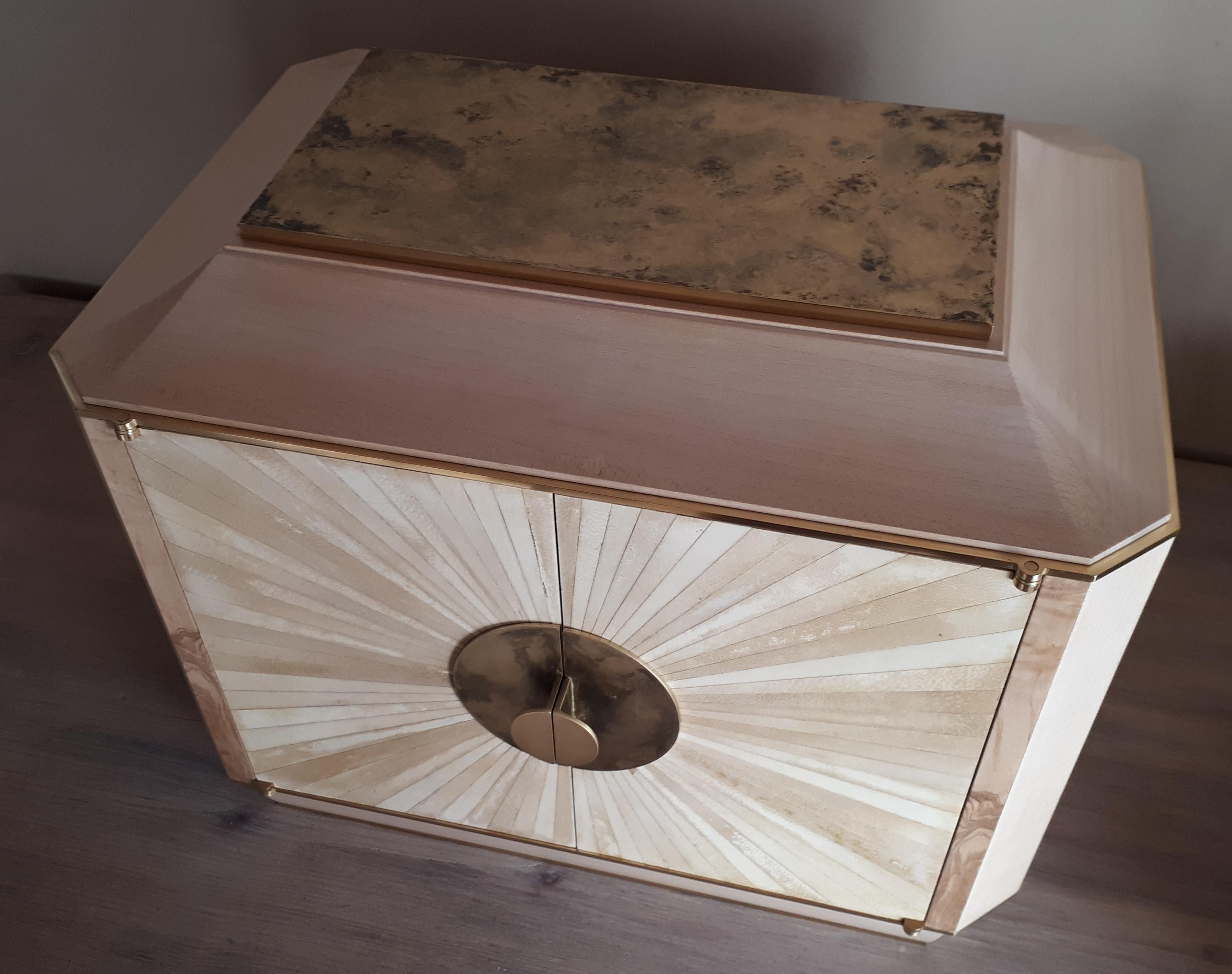 Cabinet in sycamore, ash-olive, brass, parchment and enamels with three drawers simulating nine.
Own creation.