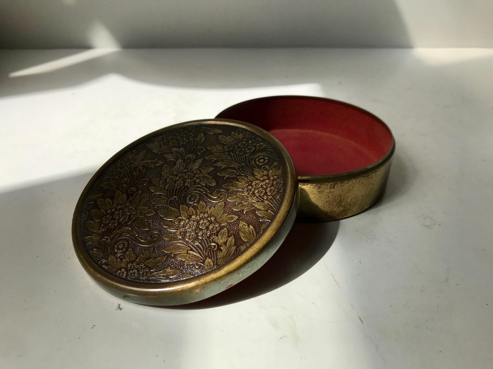 Japanese inspired jewelry trinket in bronze. The lid is hand- decorated/cut in relief depicting flowers. It has a red velvet interior slightly faded but original. This piece is marked Bronze and was made by an anonymous jeweler in Scandinavia during