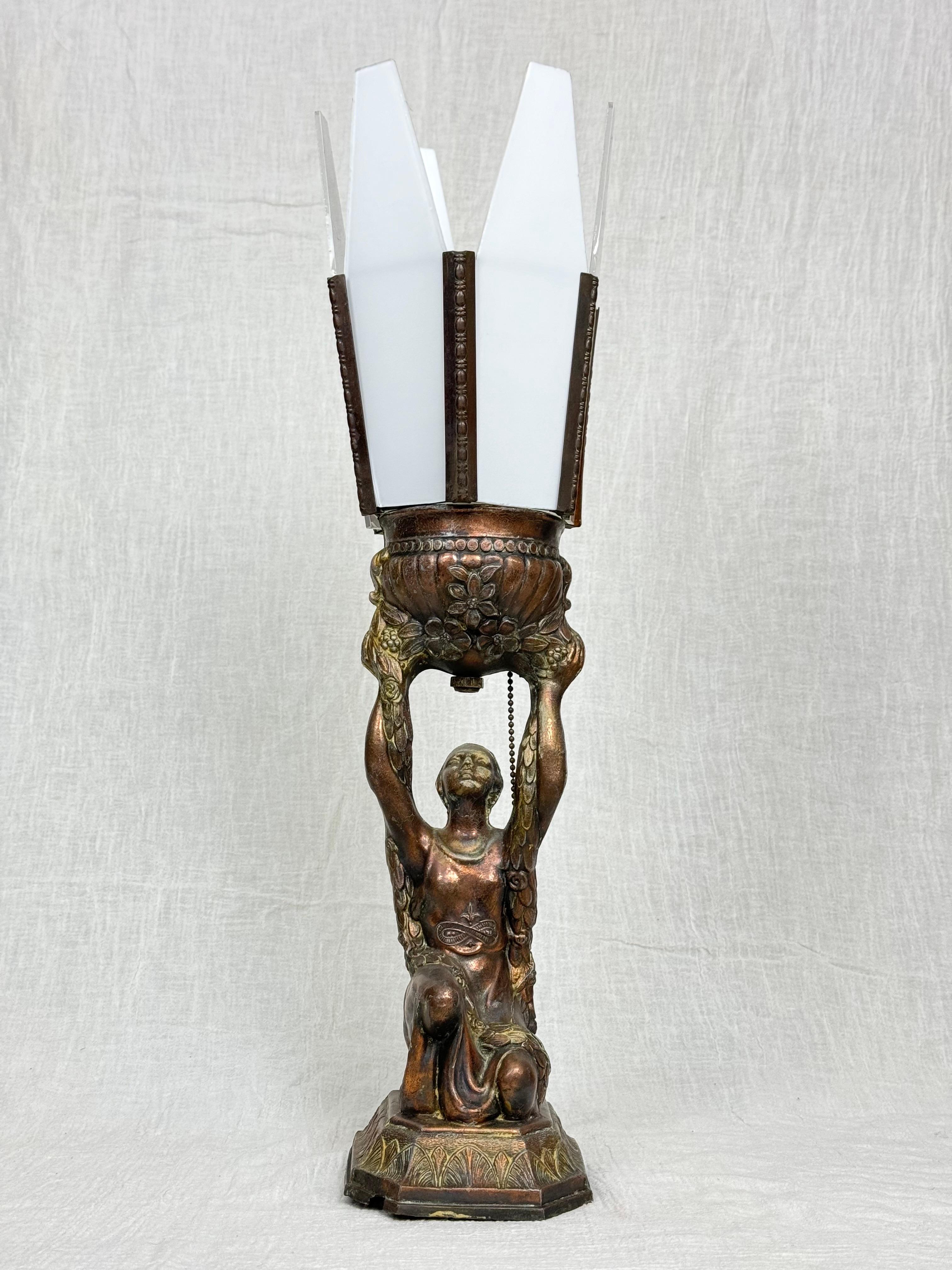 Art Deco Joan of Arc Table Lamp by  La Belle. This classic 1910 lamp by La Belle depicts Joan of Arc holding up a bouquet and kneeling on a pedestal . This lamp is made of spelter and has a milk glass shade. Classic art deco design. This lamp has