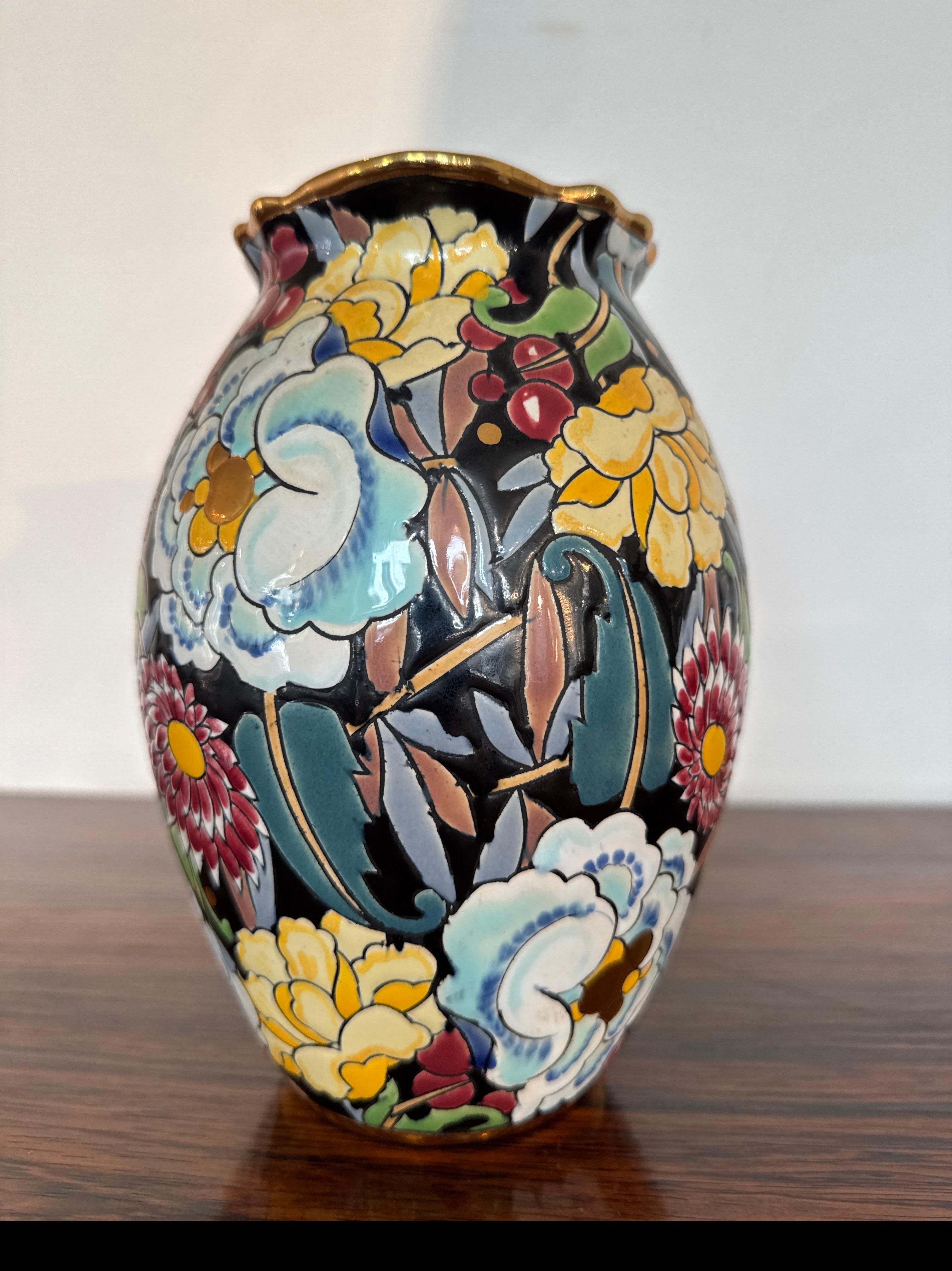 Vase Art déco à décor de fleurs polychromes et dorures de Raymond Chevalier artiste designer pour Boch Frères, La Louvière. En très bon état avec une légère décoloration de l'or sur la poignée. Décor D.2915. Signature estampillée. Une belle fleur