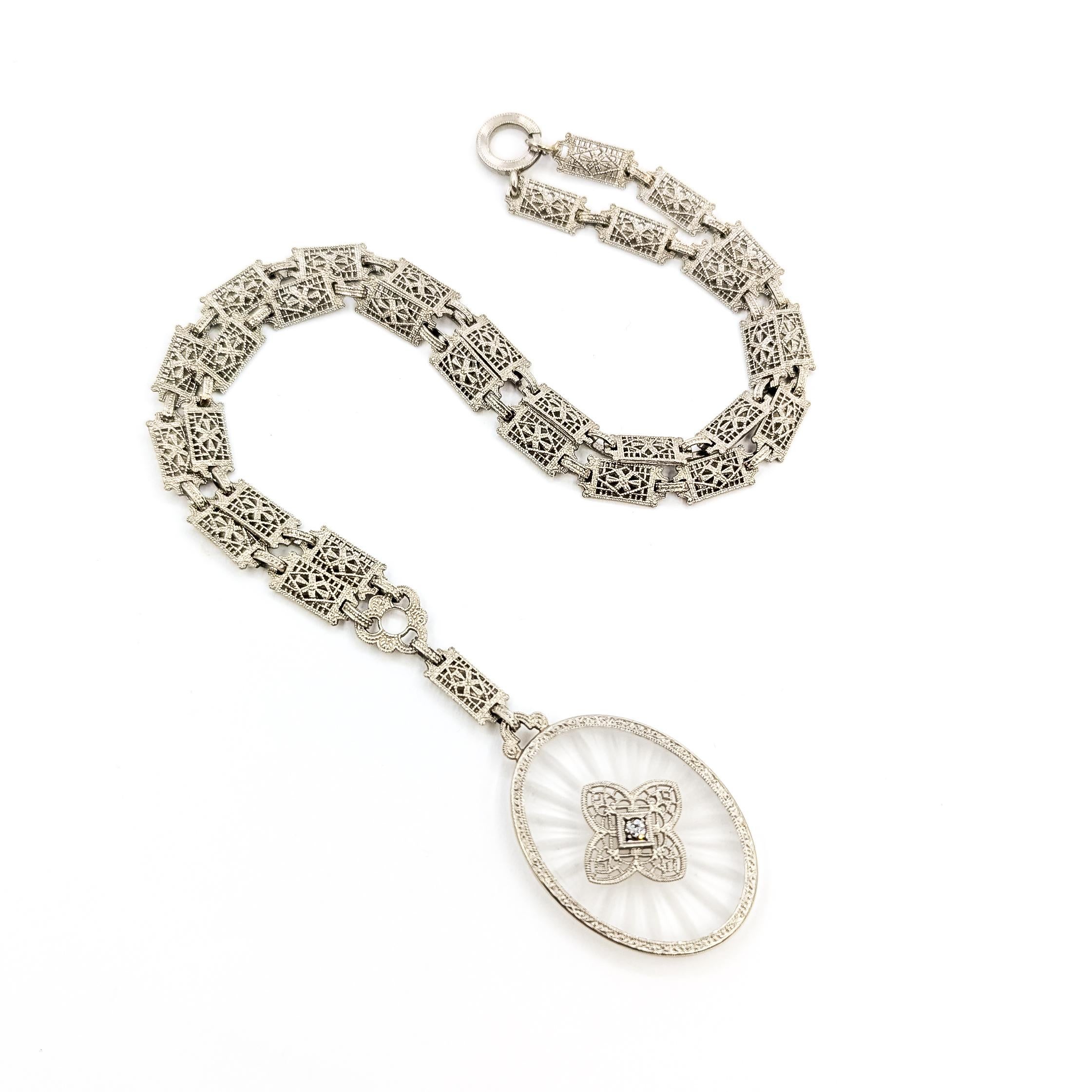 Collier Art Déco Kampfer en verre et diamants en 10k

Ce collier est réalisé en or blanc 10k et présente un diamant serti au centre d'un pendentif en verre kampfer filigrané et taillé. Véritable exemple de l'ère Art déco, cette pièce présente des