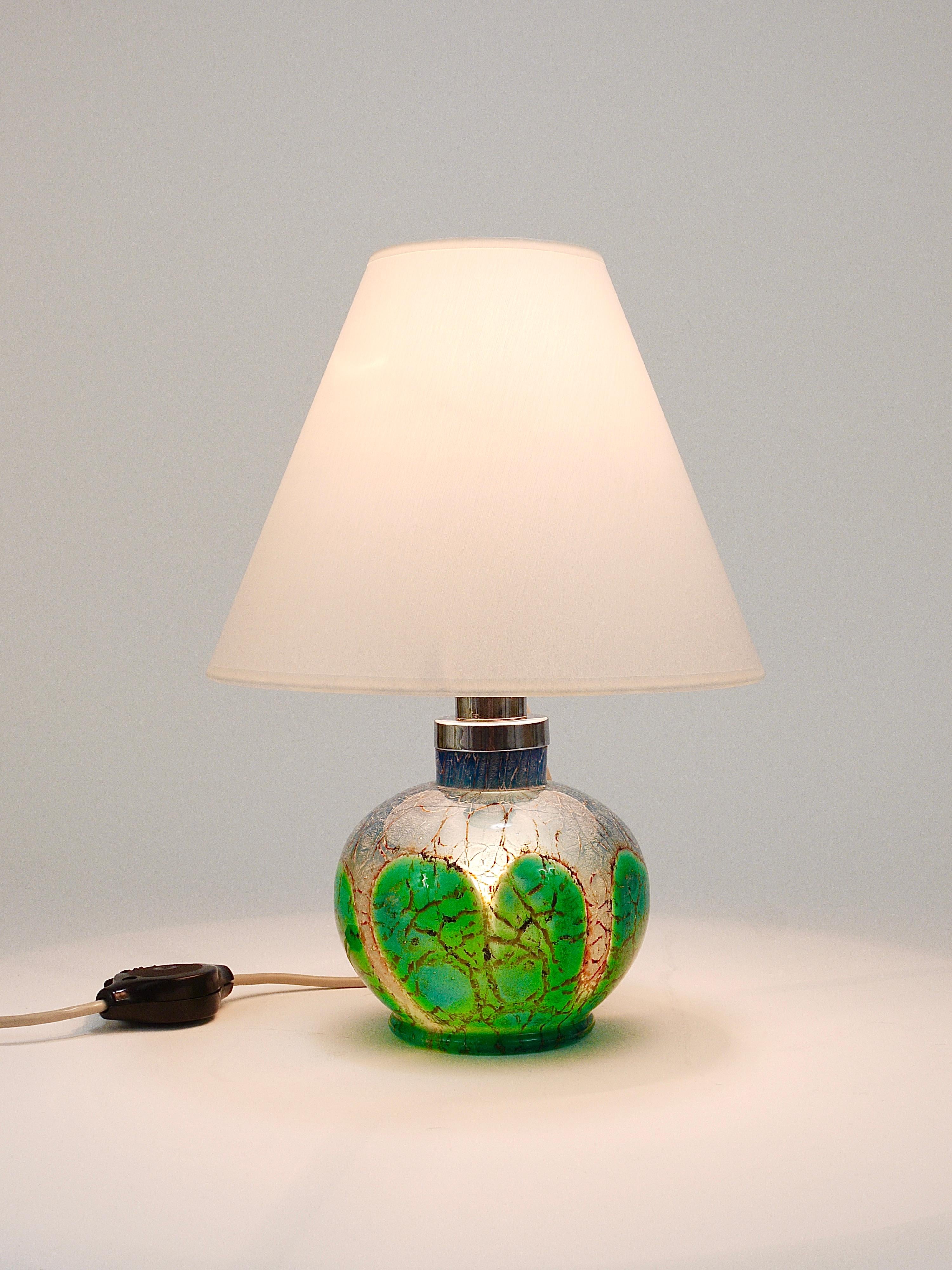 Magnifique lampe de table ou d'appoint Art déco classique des années 1930 par Karl Wiedmann, exécutée par WMF Allemagne. La lampe est dotée d'une base en verre d'art Ikora solide de couleur verte, bleue et argentée, qui peut être éclairée. Cela a
