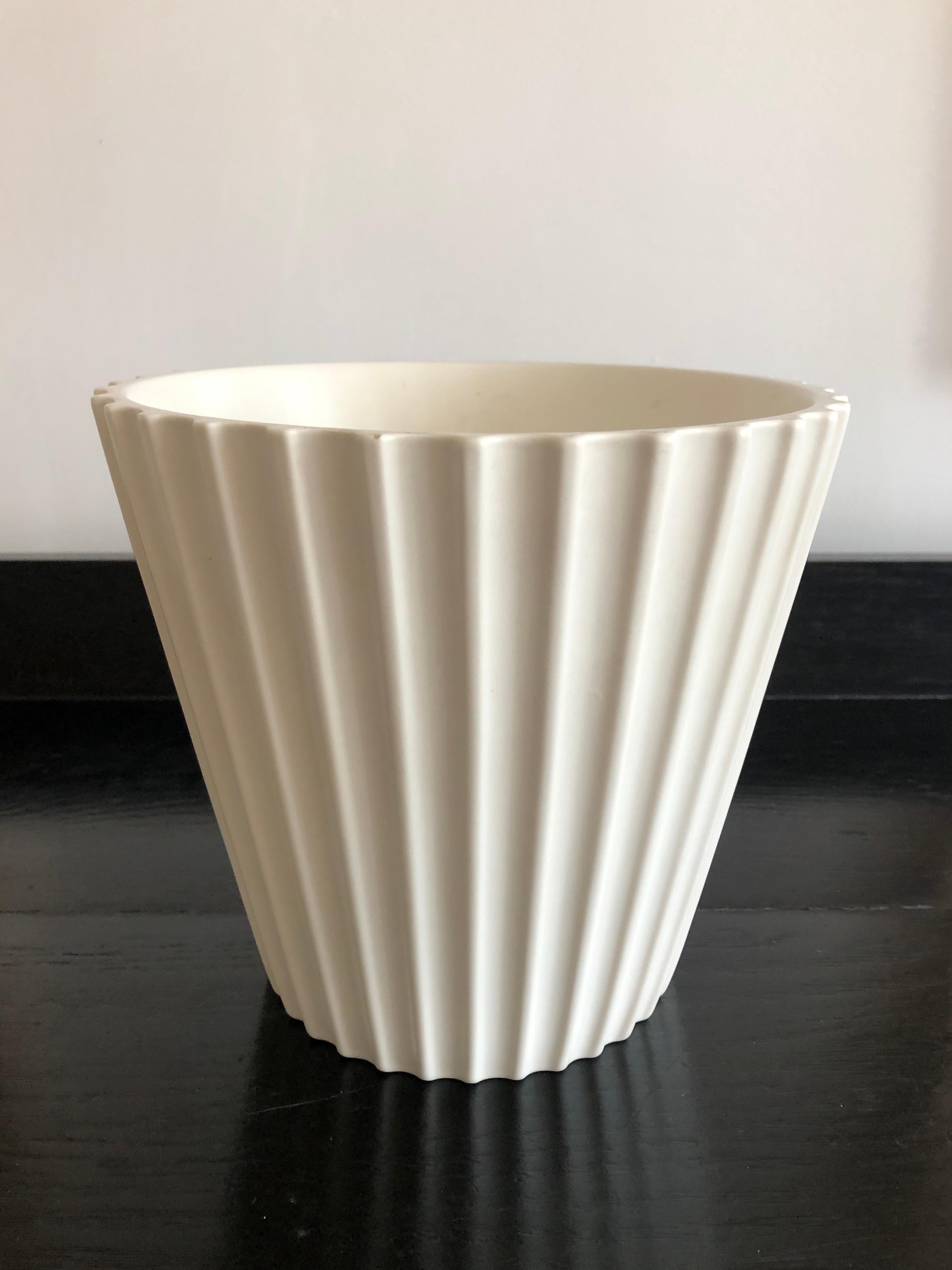 An Art Deco period white moonstone glazed vase or wine cooler, designed by Keith Murray for Wedgwood, English, circa 1930s, of tapering circular form with reeded. Signed with printed mark and paper collectors' inventory number label. We love this