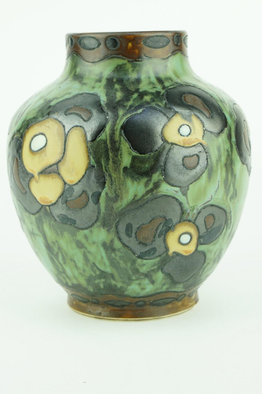 Matte stoneware Art Deco vase signed Ch. Catteau. Design 773. The design is polychrome with stylized geranium flowers and leaves. Form 888.

Measures: Size: H: 13.7 cm. Diameter base: 6.8 cm. Diameter top: 6 cm.

 