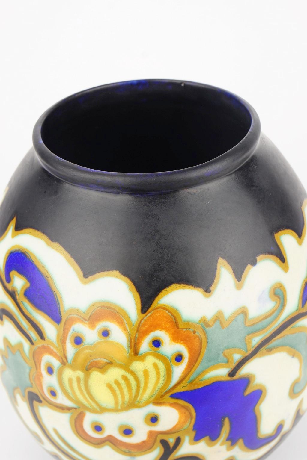 This Art Deco Keramis Boch vase has a polychrome design with a frieze of stylised flowers on a black background.

Marks: D 1276. F 900.

Size: H 18.2 cm, diameter base 11.2 cm, diameter top 9.9 cm.