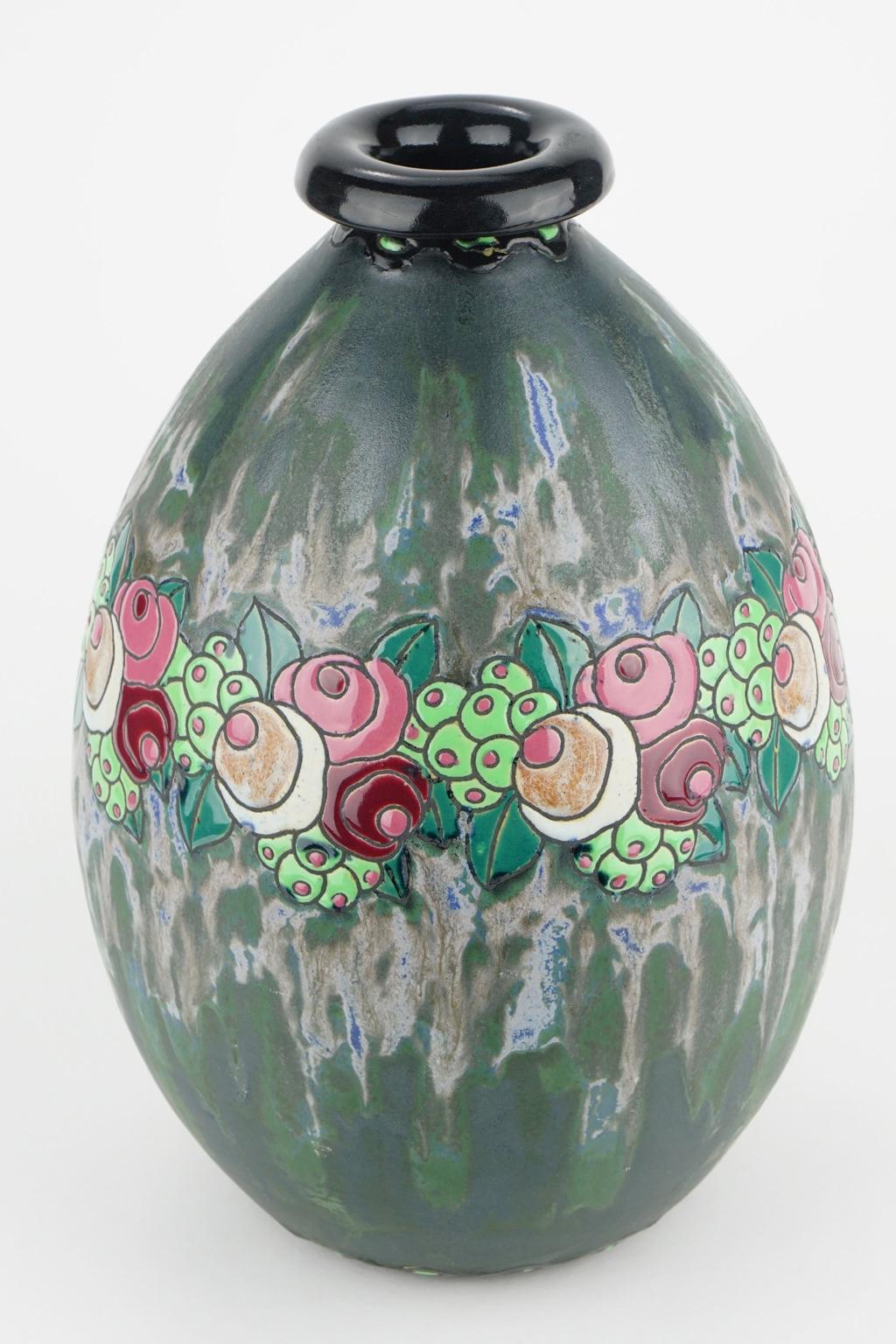 This Art Deco Keramis stoneware vase has a polychrome design with a garland of stylised small roses, leaves and fruits in a blue and dark green background. D 700. F 960. Charles Catteau (1880-1966).

Size: Height 32 cm, diameter base 9.3 cm,