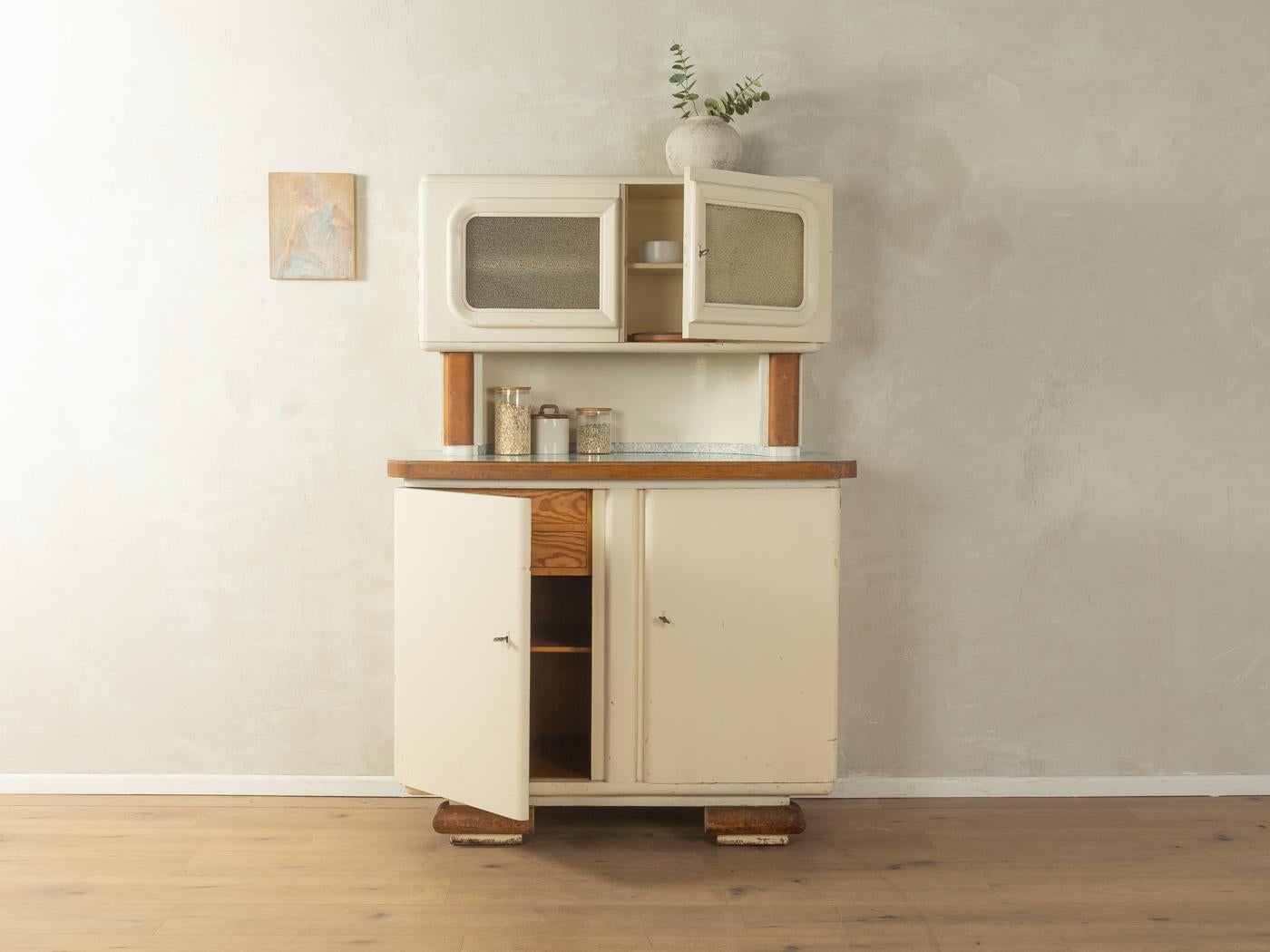 Unico mobile da cucina in due parti in stile Art déco degli anni '20. Corpo di alta qualità in legno listellare con due ante, due ante in vetro, quattro cassetti interni e due ripiani. Progettato e prodotto in Germania.

Abbiamo rinnovato