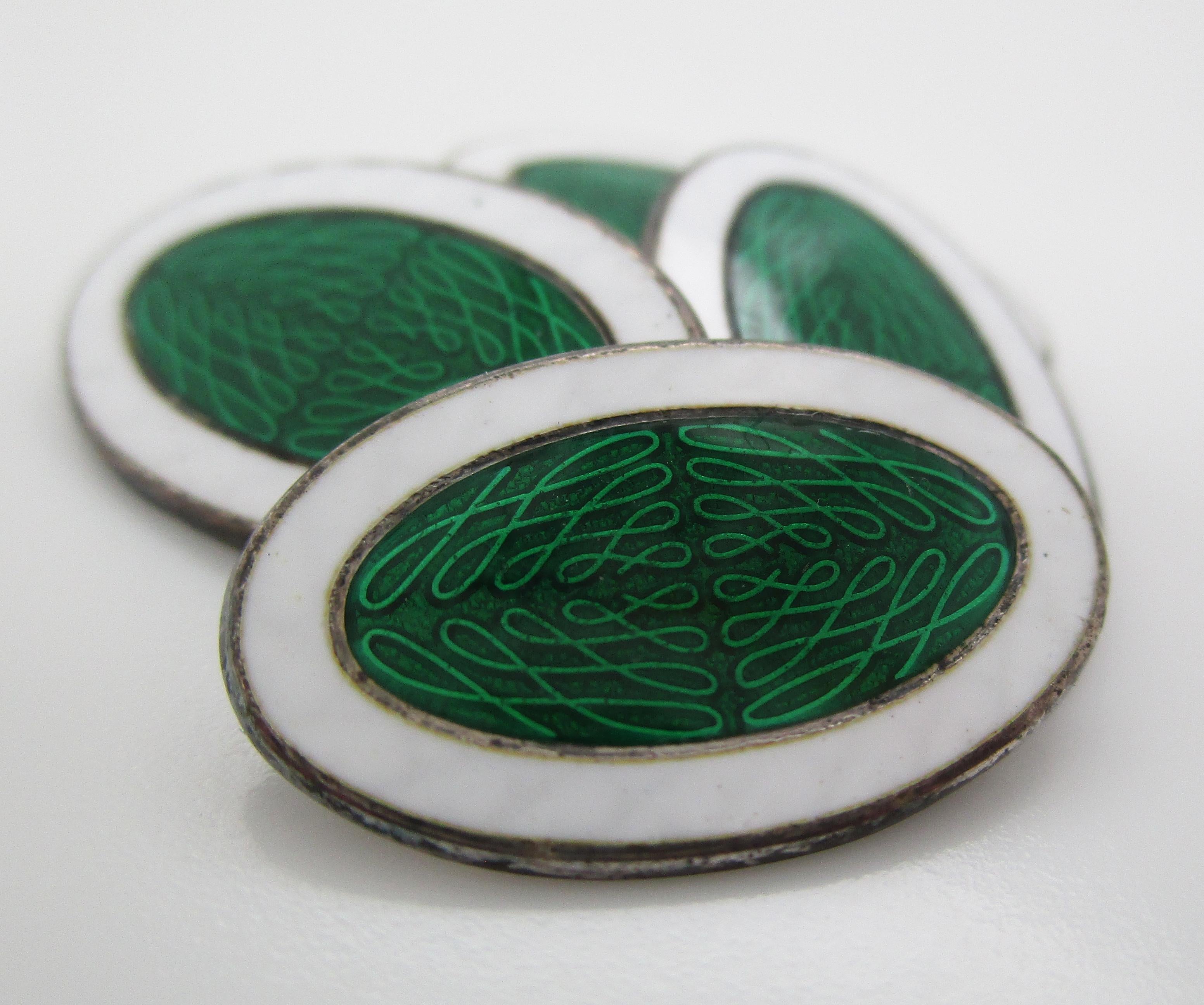 This is an excellent pair of suave Deco cufflinks in sterling silver with green and white enamel panels. The green center of the panels has great guilloche details and the white frame creates a strong terminus to an elegant link. The links have a