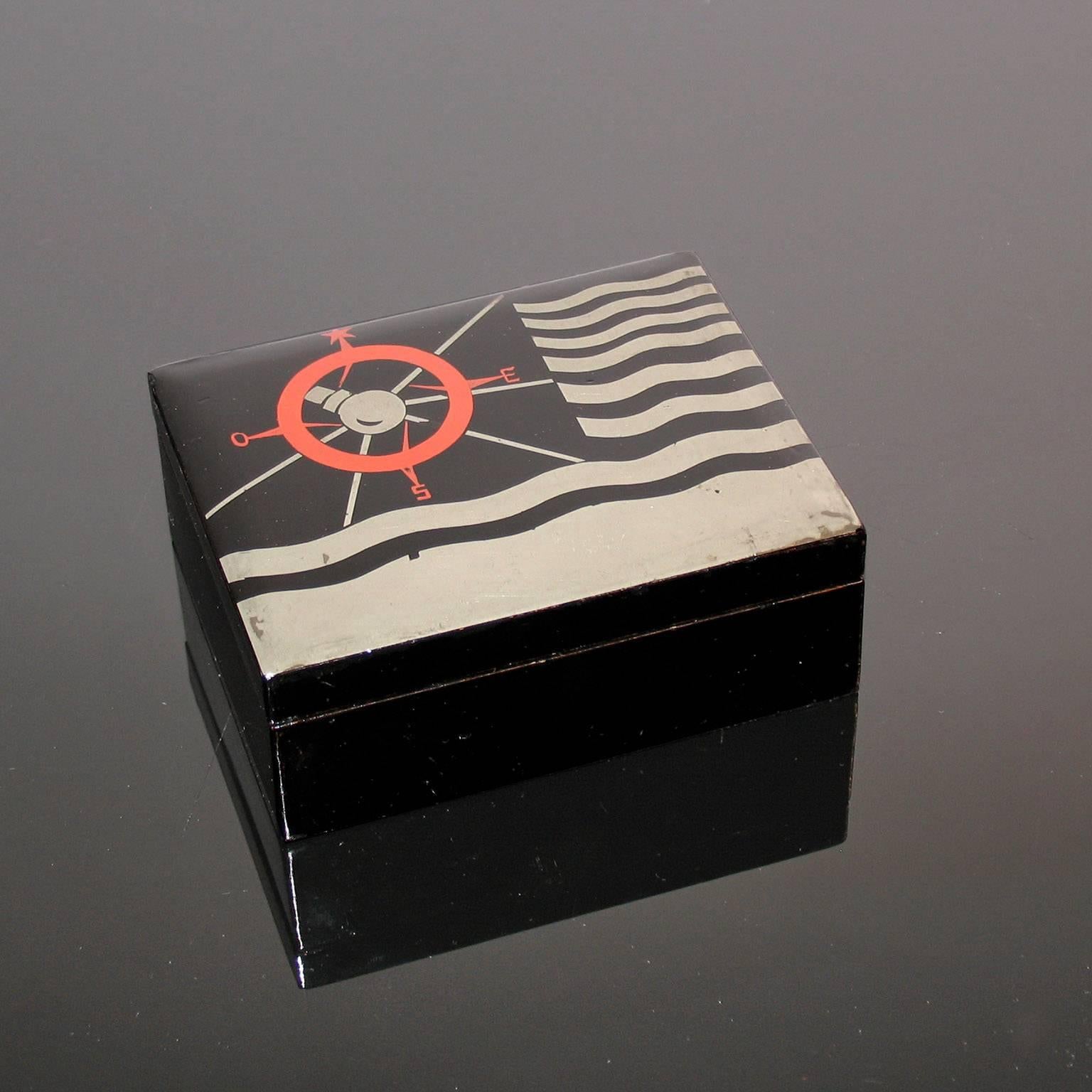 Art Deco lacquered decorative jewelry box.
Art Deco box, black lacquer background, decorated with waved silver lines and wind rose in red. Inscribed inside the lid 