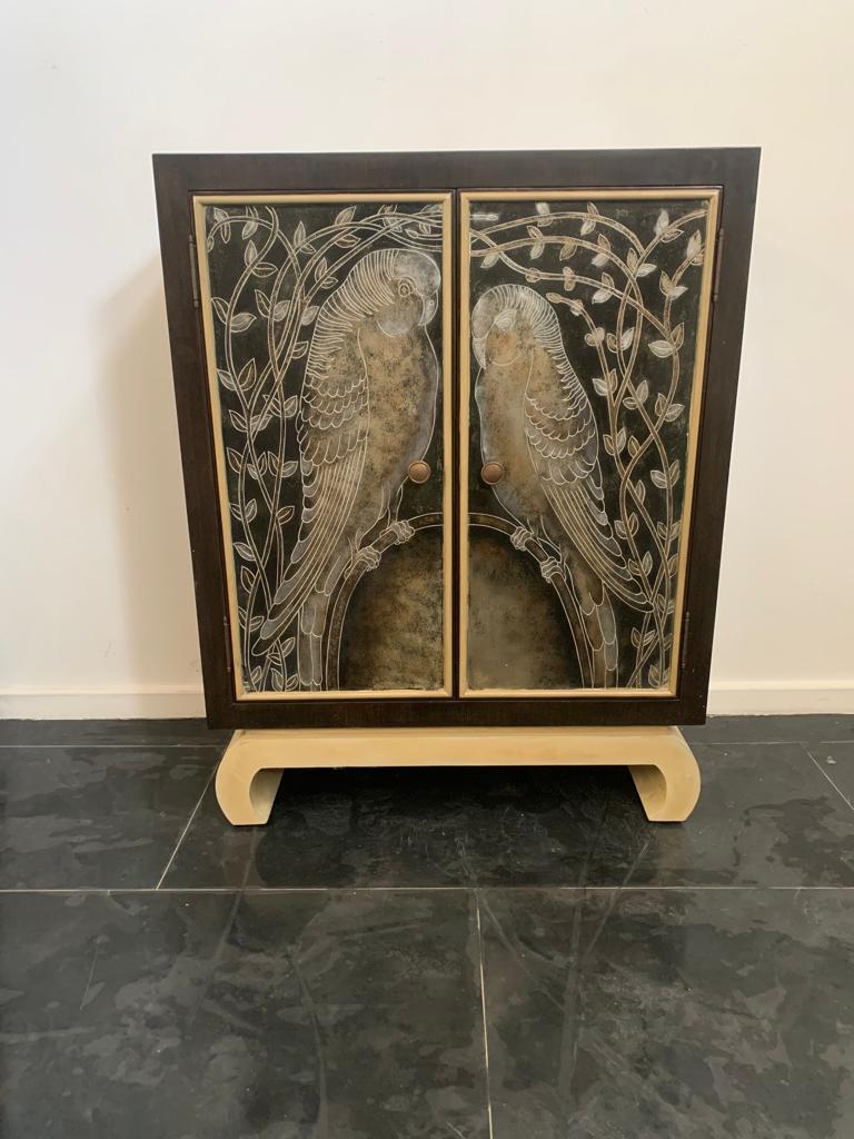 Production Lam Lee Group Dallas - O.L.F. Splendid small sideboard in the style of the great French decorators of the 1920s. Brown lacquered body, antique ivory lacquered base and door frames, in the centre stands out the decoration of two parrots
