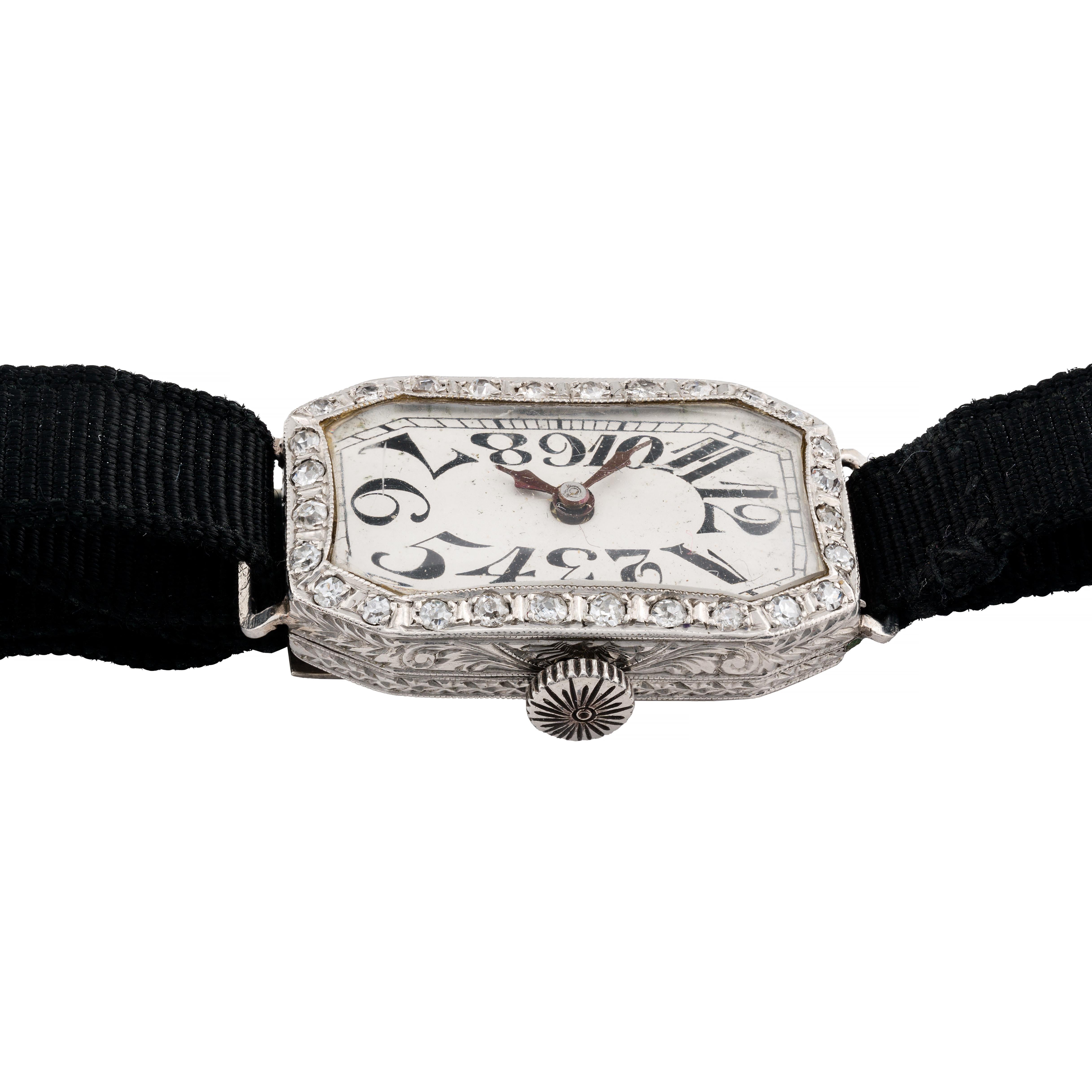 Aston Estate Jewelry Presents:

A classic wristwatch with a rectangular shape, crafted in platinum, featuring a manual wind movement.

The watch showcases a silver dial adorned with bold Arabic numerals, adding a distinctive touch to its design. The