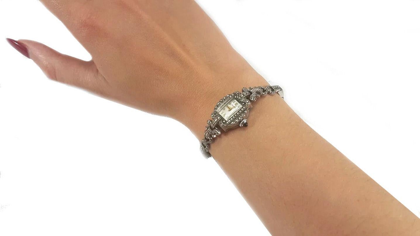 This is a stunning Art Deco marcasite cocktail watch by Premex. The rectangular face has gold numbers and hands which add an extra touch of class to the watch. The strap and case are silver plated and in excellent condition with no missing
