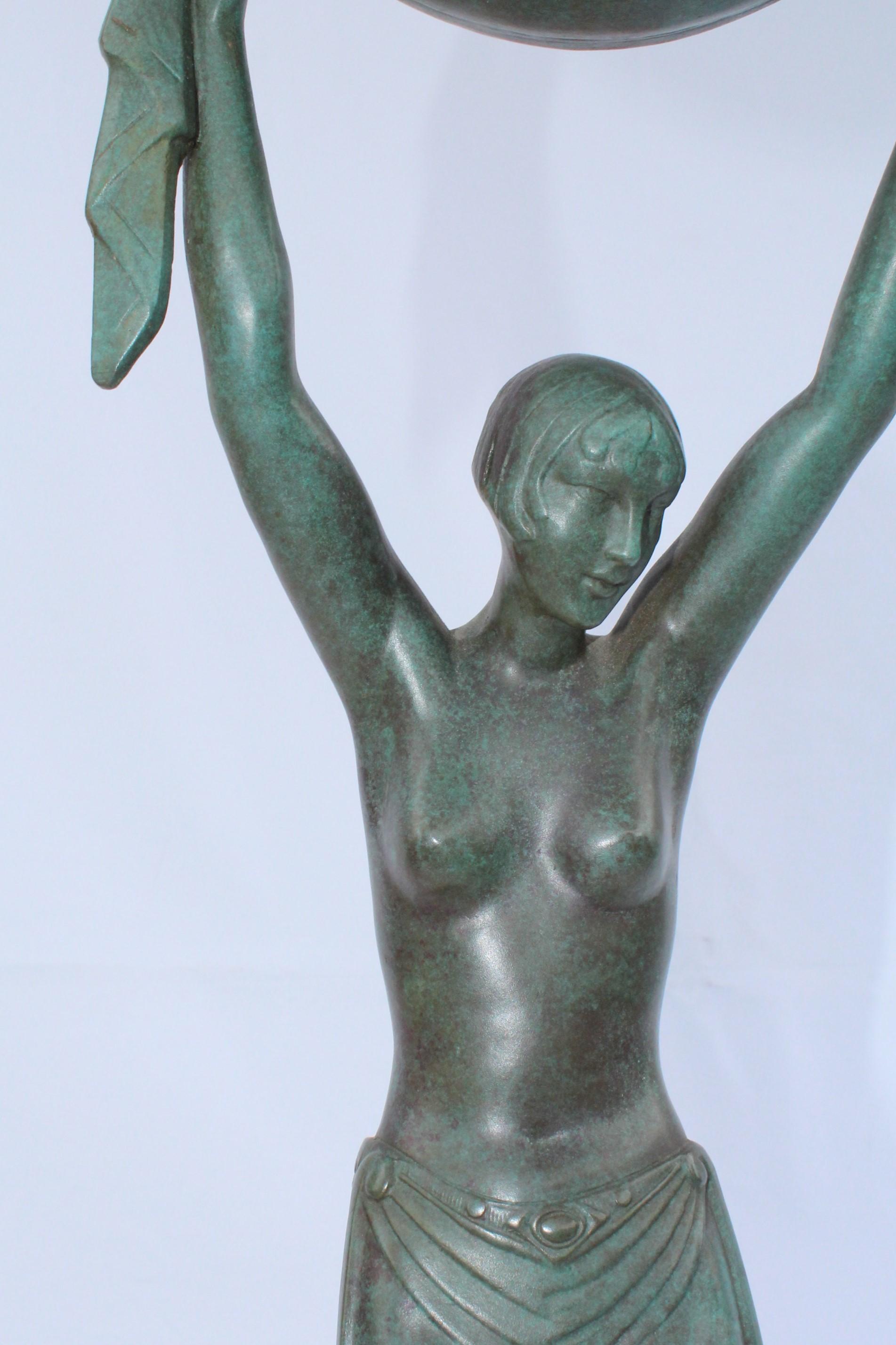 Semi-nude girl holding a globe as a lamp. Has a great green patina finish and is mounted on an absolute black marble base. Has the marks in the bronze of (Fayral) on the back side. Real nice lamp 27 1/2