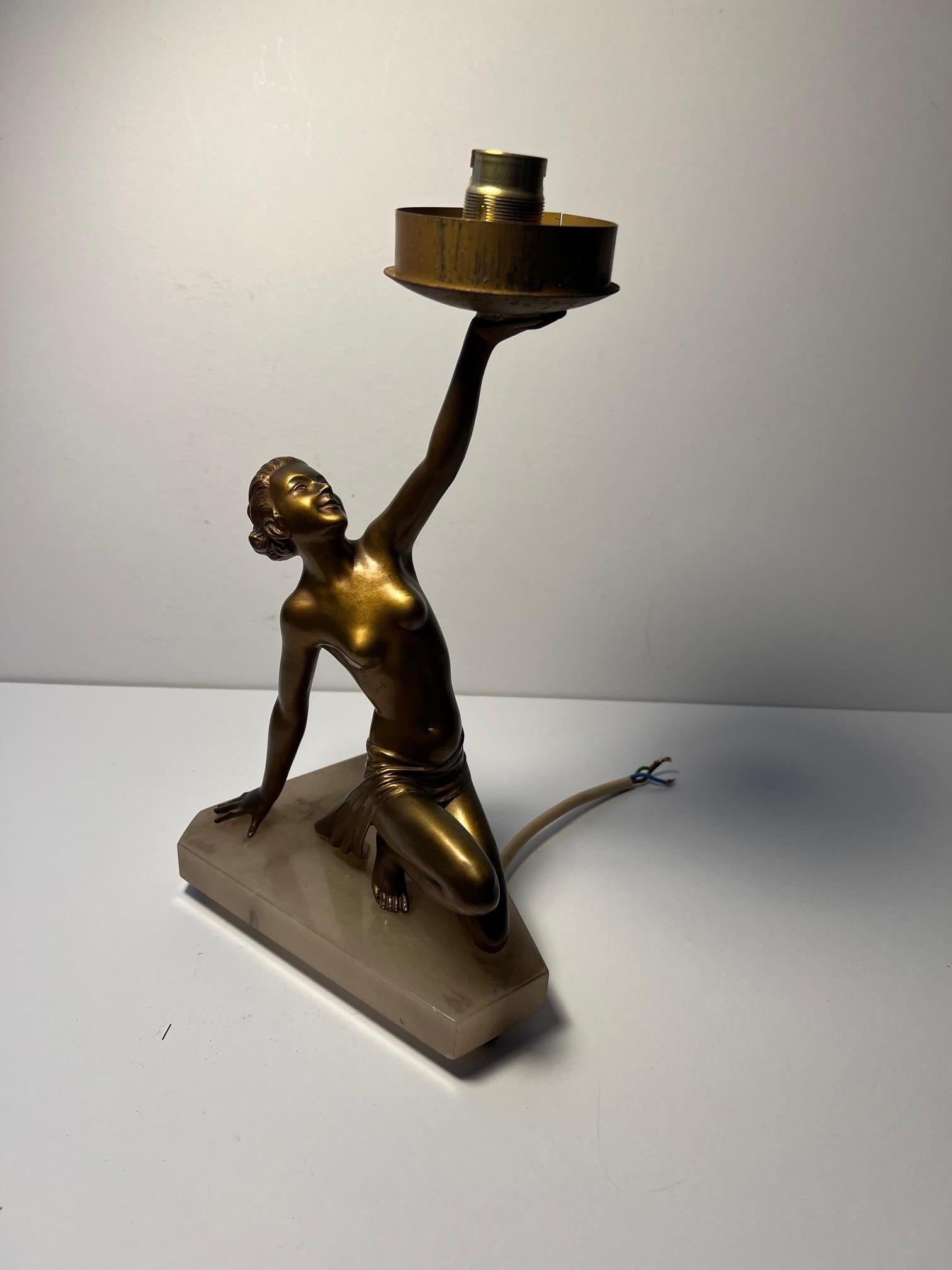 Lampe de dame art déco.

Lampe de table pour dame de style art déco / nouveau, de qualité supérieure à la moyenne. Original des années 1920/1930.

Le modèle est une femme semi-nue au physique athlétique qui tient en l'air un abat-jour en verre