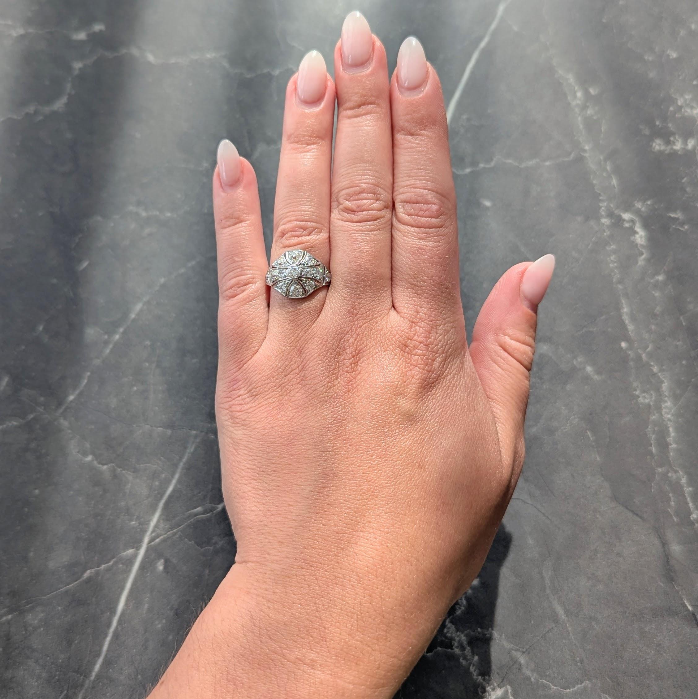 Centering an old European cut diamond weighing 0.18 carat total - H color with VS2 clarity
Set with tab-like prongs in a pierced geometric motif bombé shaped surround
Flanked by pierced shoulders with milgrain detail and diamonds throughout
Weighing