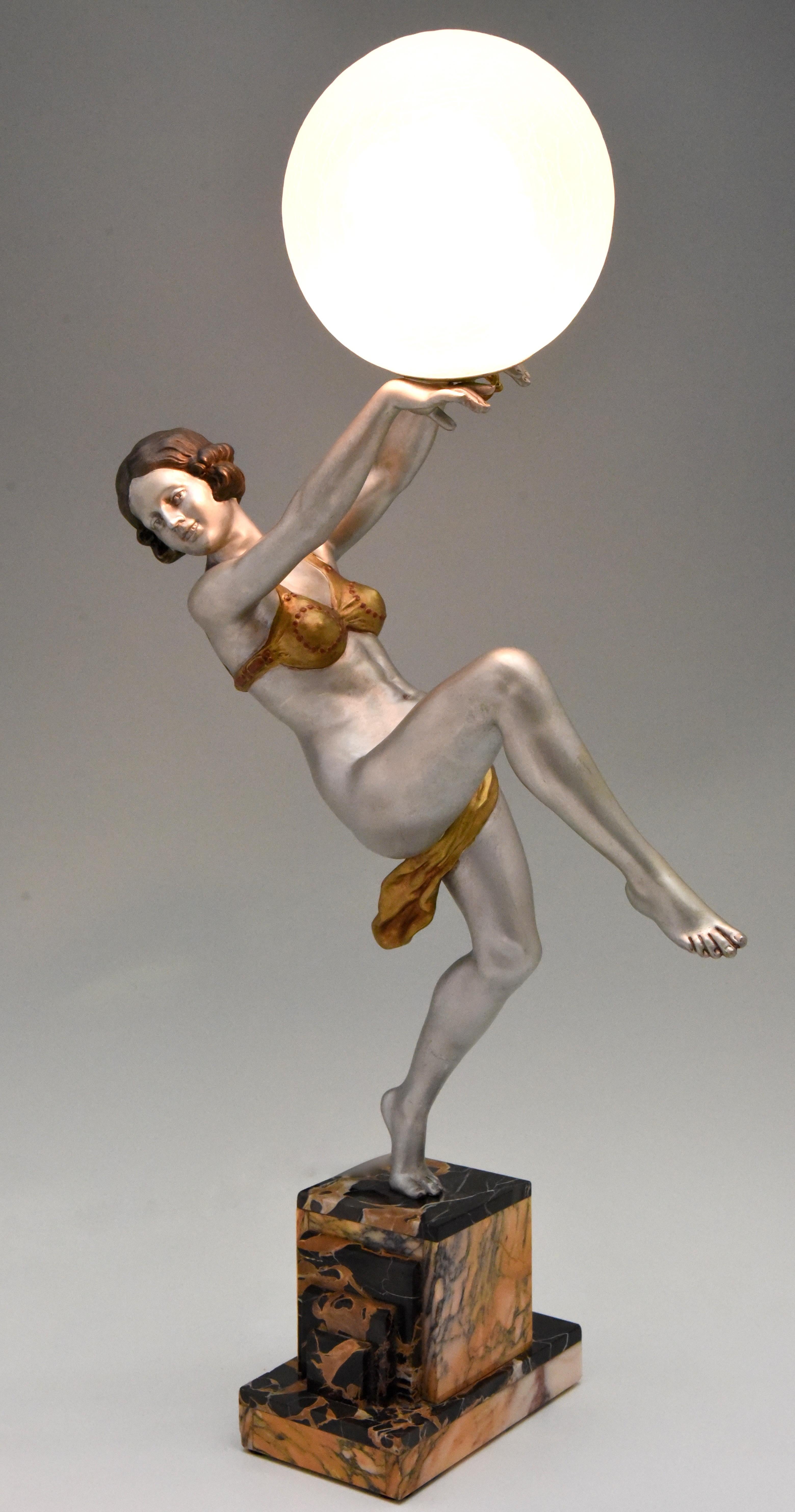 Impressive Art Deco lamp nude lady holding a ball signed by the French sculptor Emile Carlier. The white metal figure has a lovely silver and gold patina and stands on a Fine marble base. 

A similar dancer is illustrated on page 440 of the