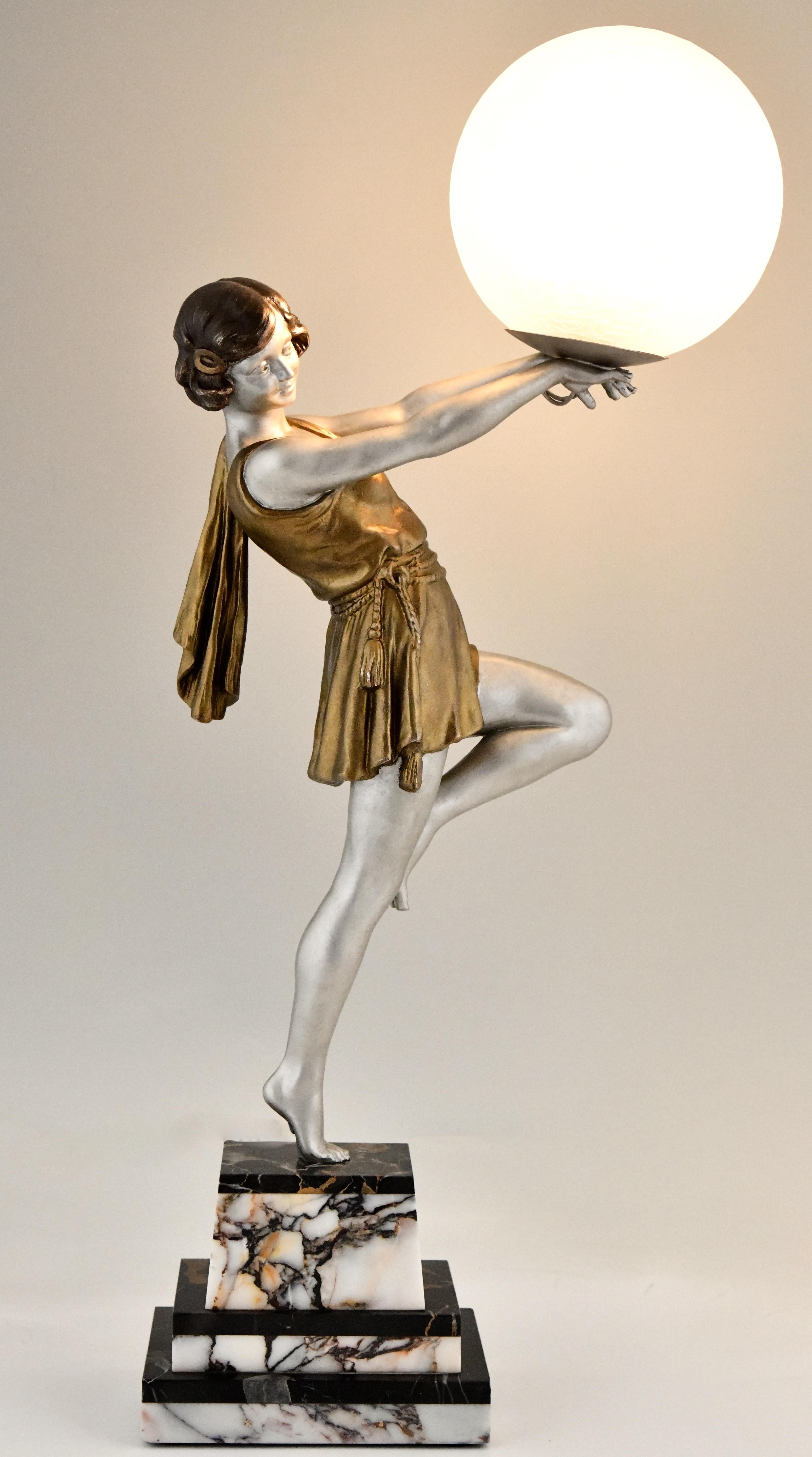 Art Deco lamp lady holding a ball by Emile Carlier
White metal with silver and golden patina on a black and white marble base.
Crackle glass shade.
France 1930.