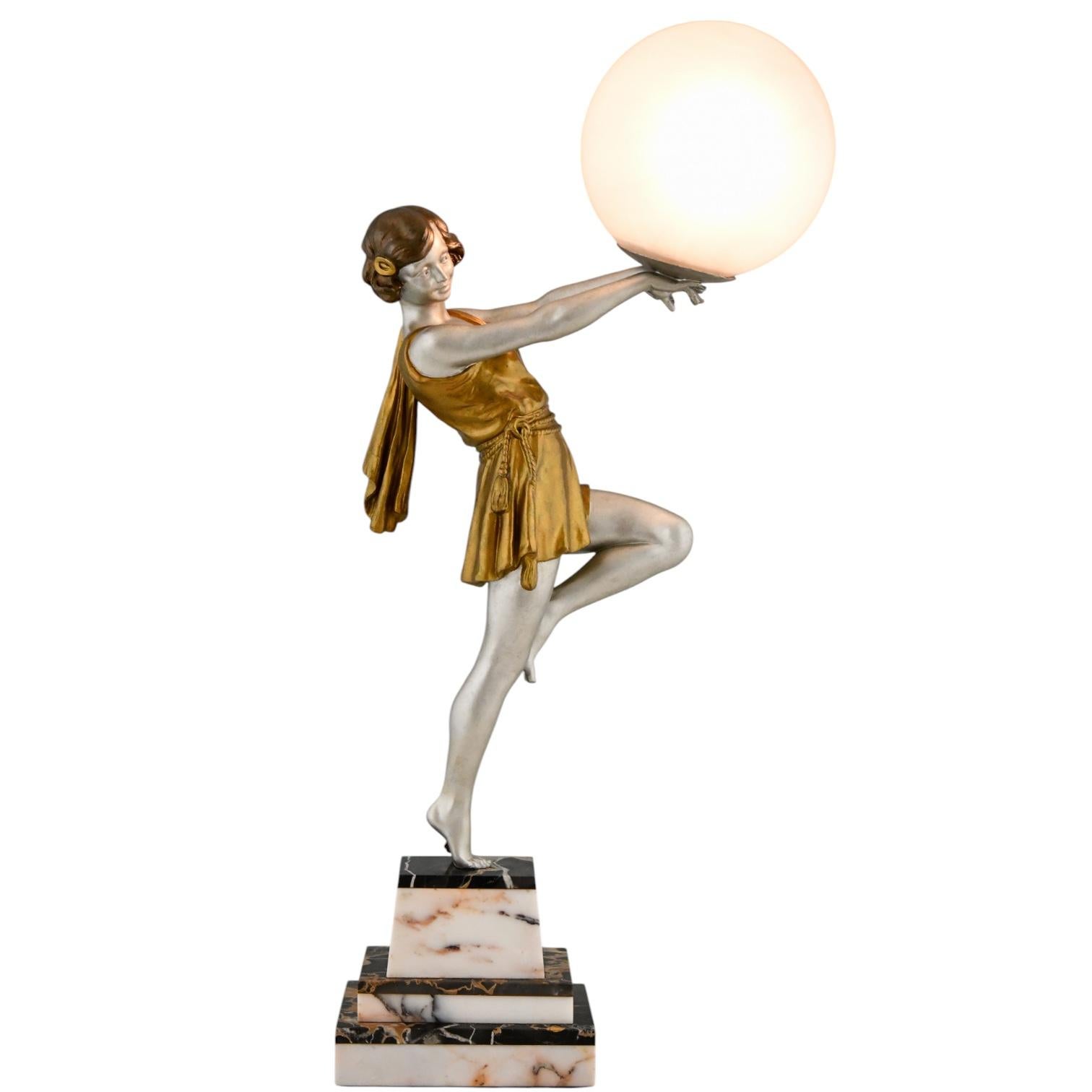 Lámpara Art Déco Dama sosteniendo una pelota de Emile Carlier
Metal blanco con pátina plateada y dorada sobre una base de mármol blanco y negro.
Pantalla de cristal craquelado.
Francia 1930.
Este modelo, como escultura, está ilustrado en la página