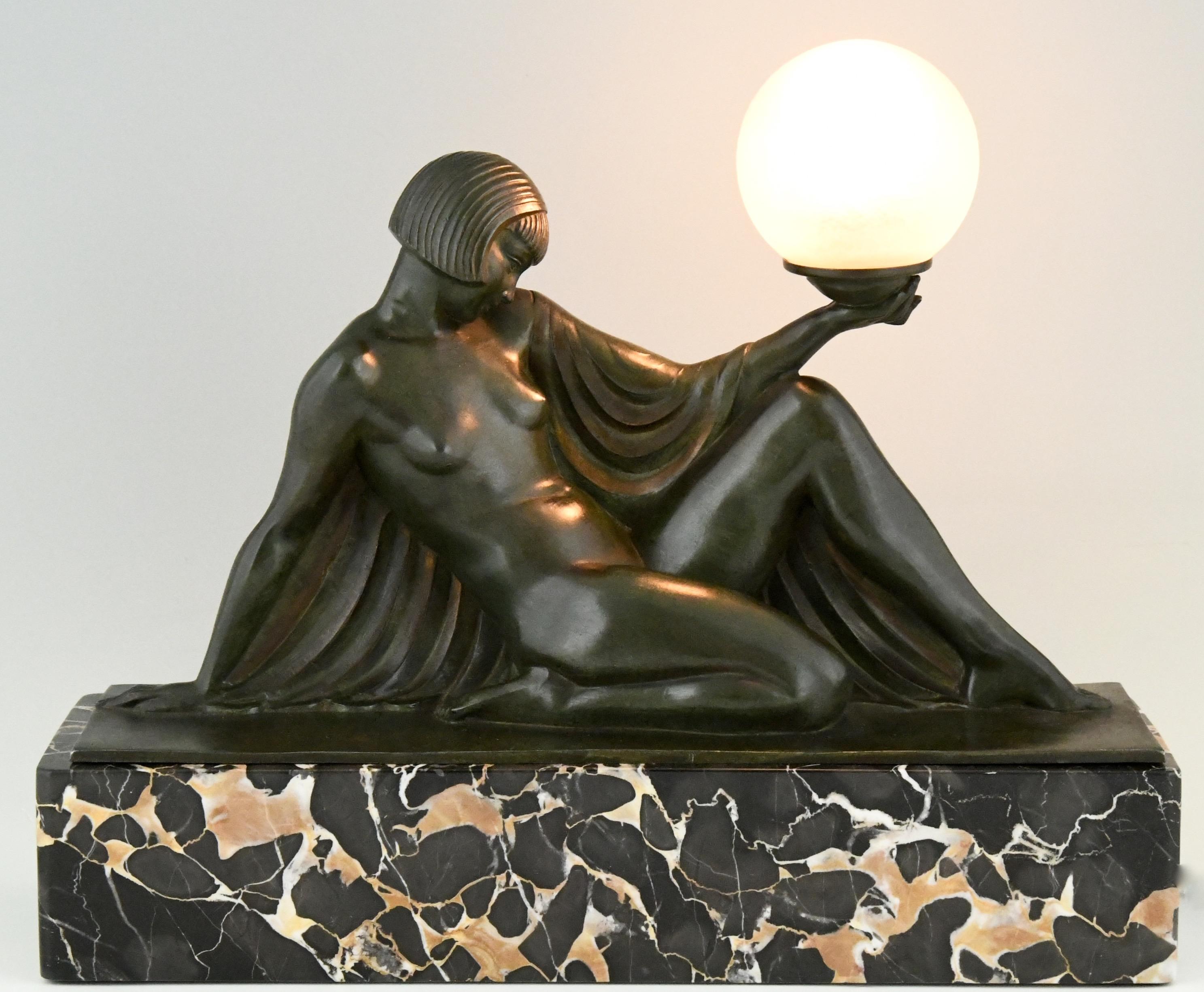 Rèverie original Art Deco lamp seated nude with drape holding a globe by Raymonde Guerbe for Max Le Verrier. With the original glass globe signed by Daum Nancy, France. Art metal sculpture with dark green patina mounted on a Portor marble base.