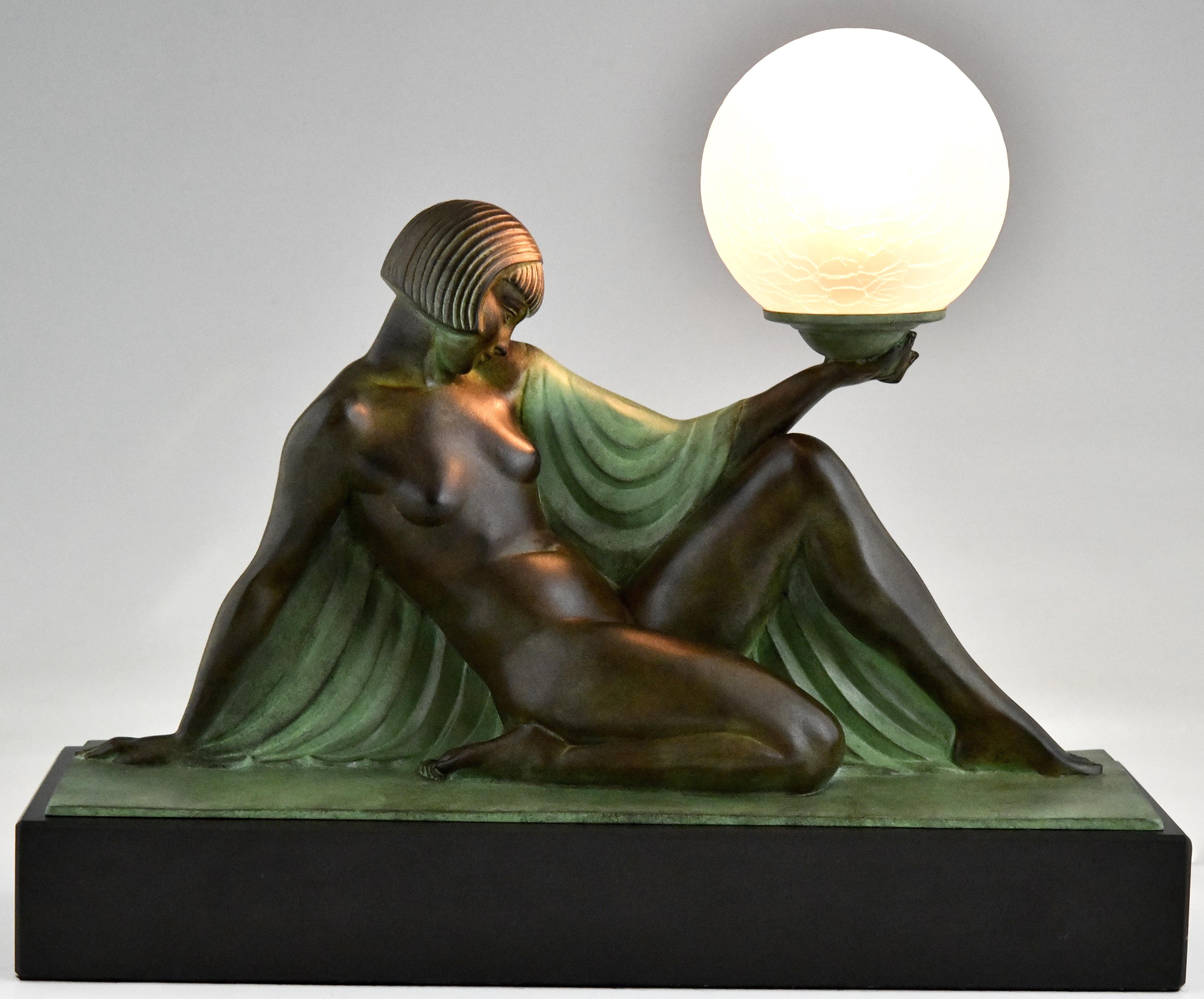 Rèverie Lámpara de estilo Art Déco desnuda sentada con drapeado sosteniendo un globo terráqueo, de Raymonde Guerbe para Max Le Verrier. Francia.
Con sello de fundición Le Verrier.  
Diseño 1930. Reparto contemporáneo póstumo. 
Hecho a mano.