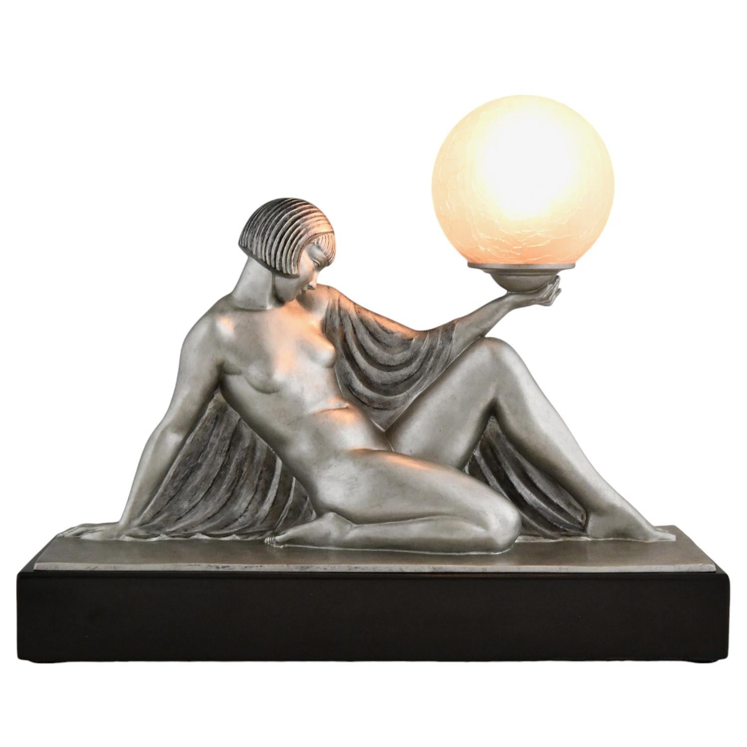 Rèverie Art Deco lamp seated nude with drape holding a globe by Raymonde Guerbe for Max Le Verrier. 
Art metal sculpture with silver patina mounted on a Belgian Black marble base & glass shade. 
France 1930.

This lamp is illustrated in:
Max le