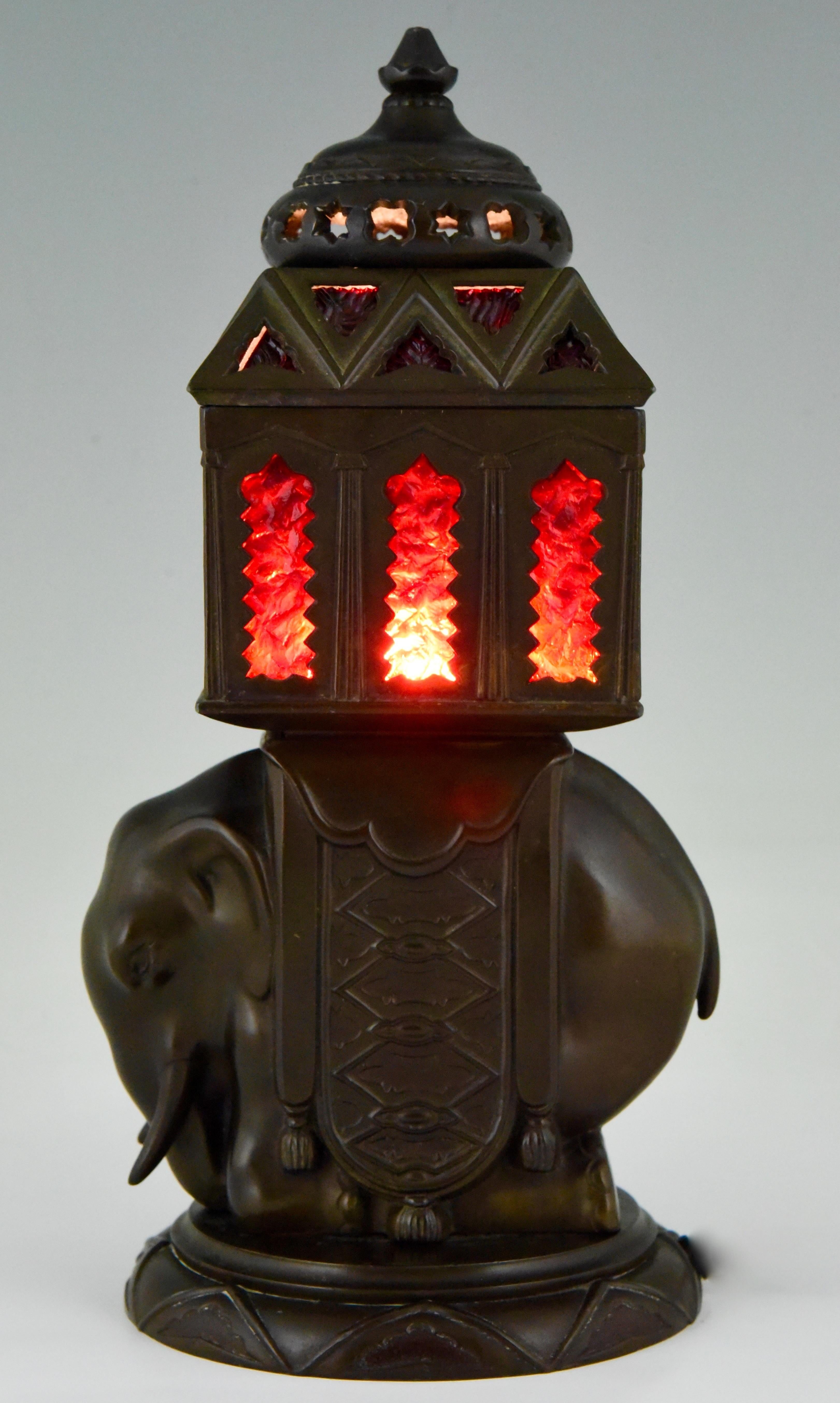 Art Deco patinated art metal lamp with elephant and red glas inlay.
France, 1930.