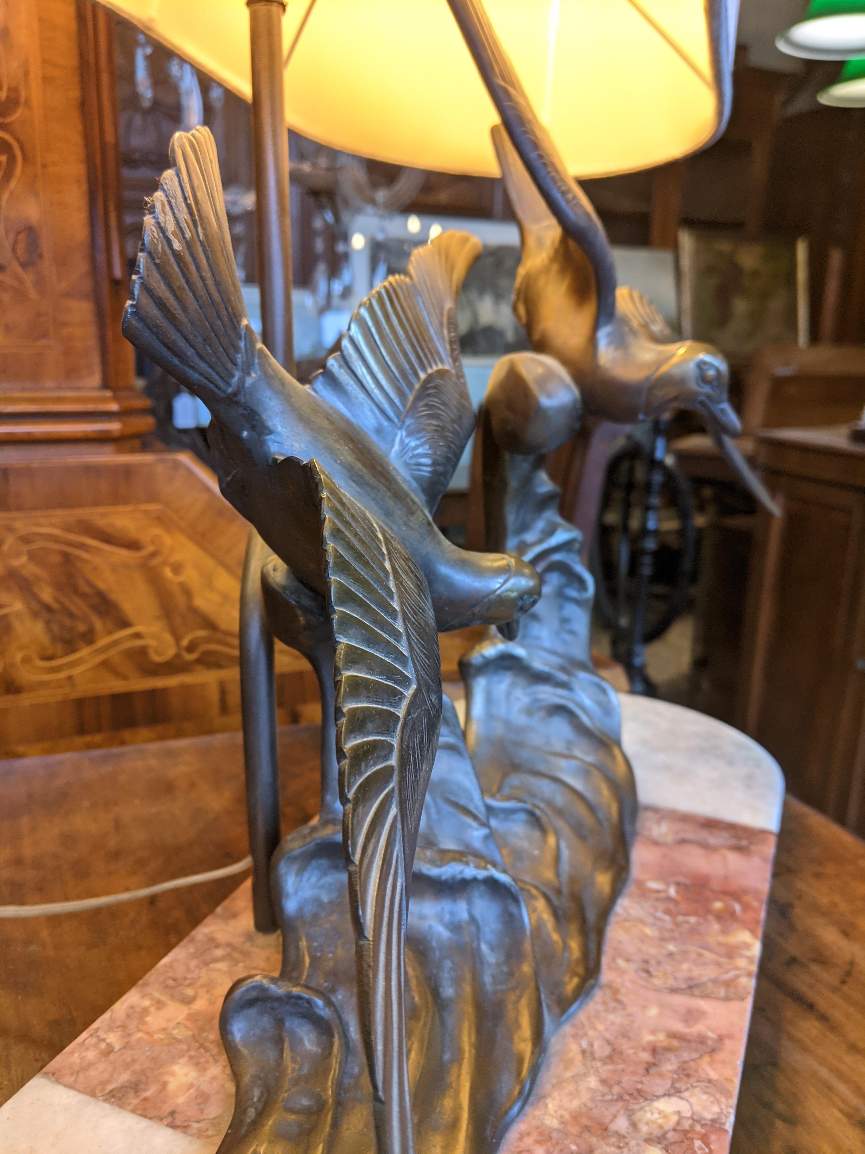 Art Deco lamp signed by Charles Henri Molins, made of bronze and marble, depicting two seagulls flying over the waves of the sea.
In perfect working order with recently redone electrical system.