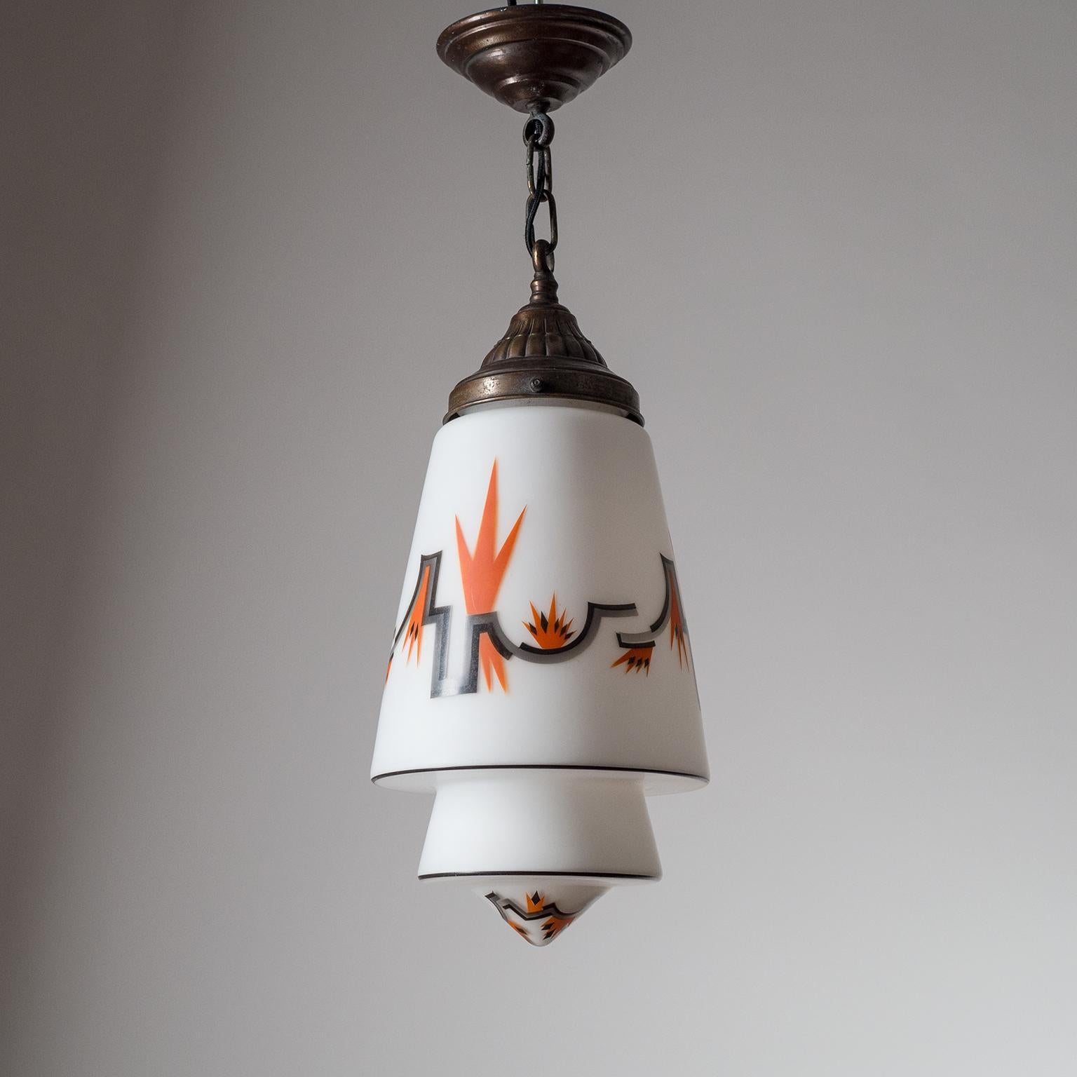 Rare enameled glass and brass Art Deco lantern, circa 1930. Beautiful conical and tiered satin glass diffuser with geometric and abstract 'flames' decor in black, grey and dark orange. The hardware is dark patinated brass. One original brass and