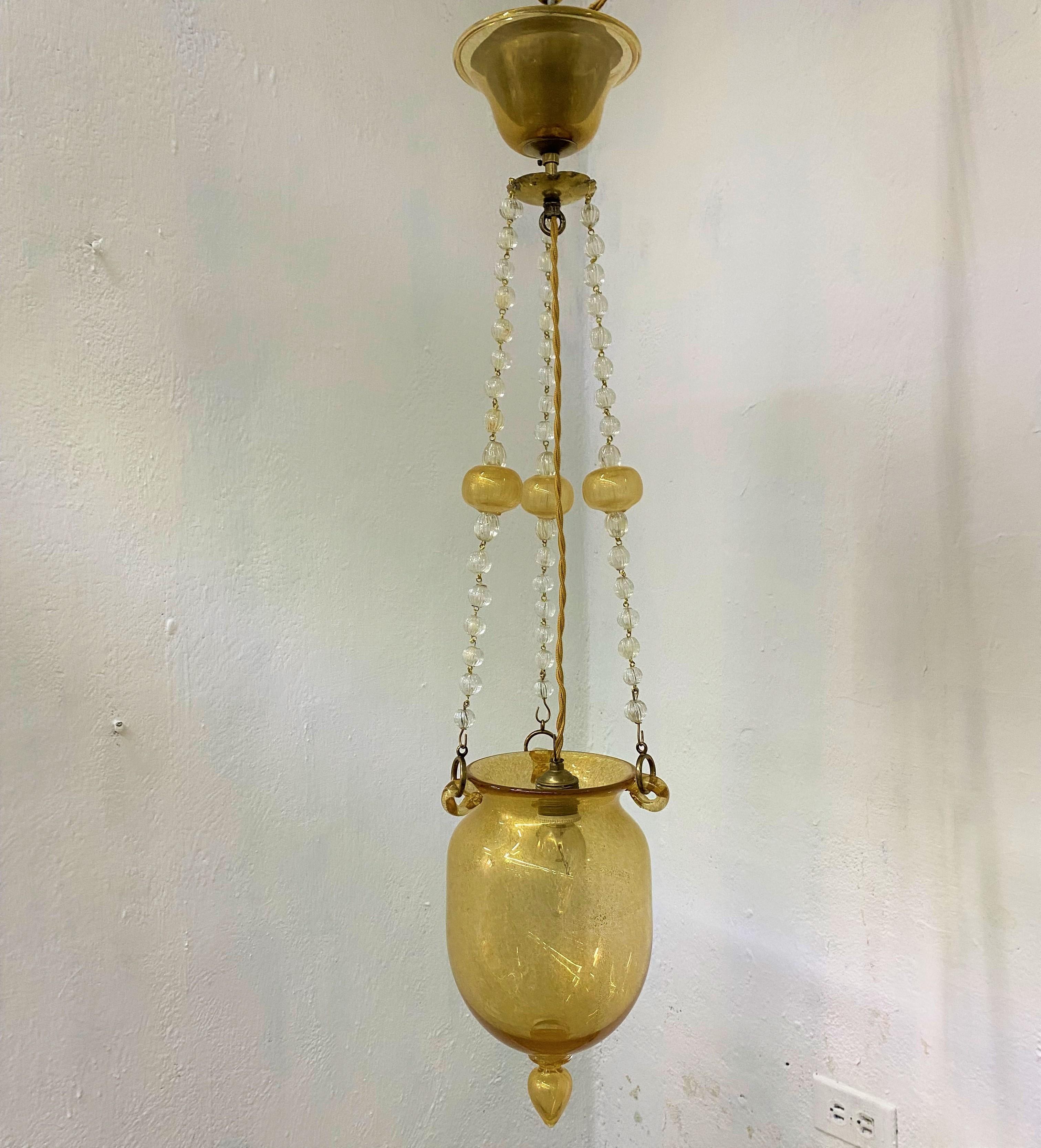 Beautiful Art Deco pendant lantern attributed to Barovier e Toso in hand blown clear and gold leaf Murano glass and brass (can be polished if desired) circa 1930.
Total height is 90cm, width is 19cm.
No breaks or repairs, recently rewired for 110v.