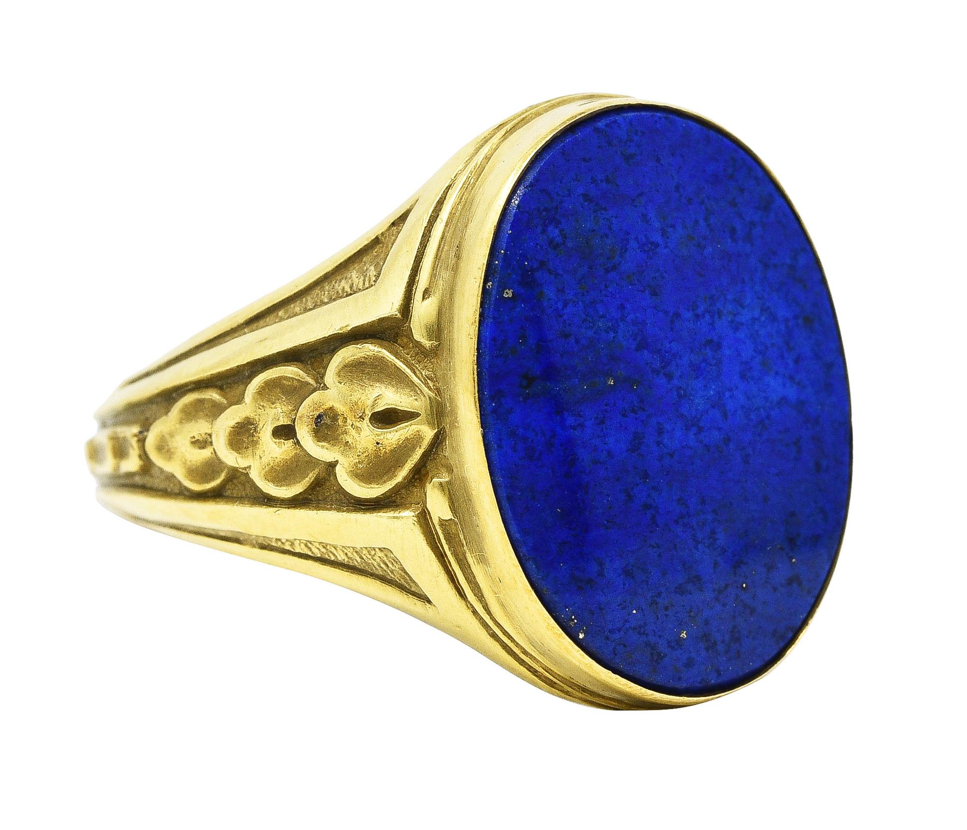 Signet style ring features an oval face measuring approximately 18.0 x 14.0 mm. Flushly inset with an oval tablet of lapis lazuli. Opaque and strongly ultramarine blue in color with subdued mottling and very few gold pyrite flecks. Mounting is