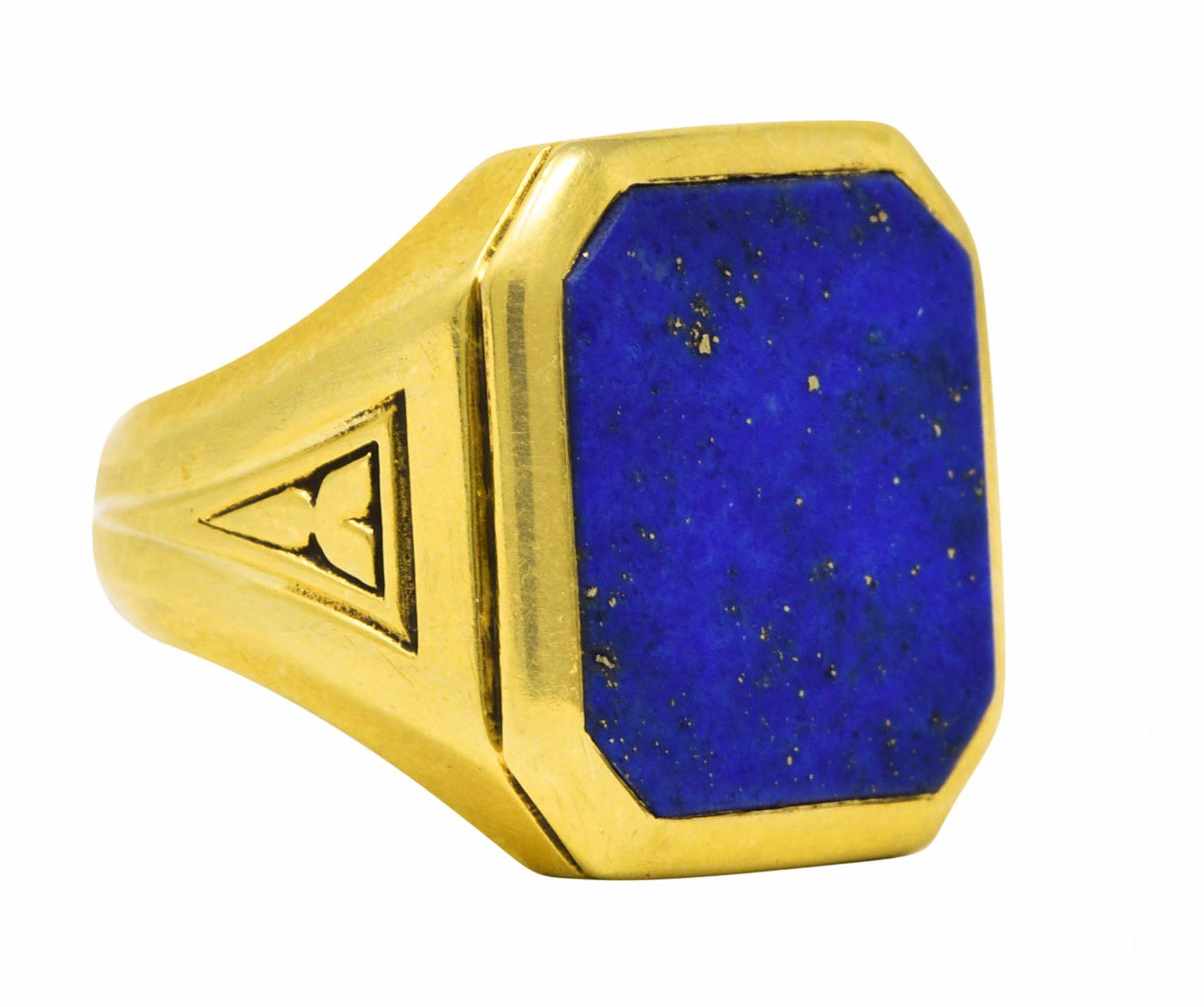 Ring centers an octagonal tablet of lapis lazuli measuring 13.5 x 15.5 mm

Opaque medium ultramarine blue with mottling and subtle pyrite flecking

Flanked by faceted shoulders with stylized trefoil engraving

Inscribed with 'E.M.A to R.B FC' inside
