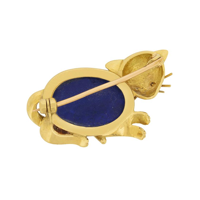 This quirky art deco style brooch takes the form of a cat. The body is made up of a cabochon cut lapis lazuli, which has a vibrant blue colour. The outline of the cat is made of 18 carat yellow gold. This would make a great gift for a cat lover!   