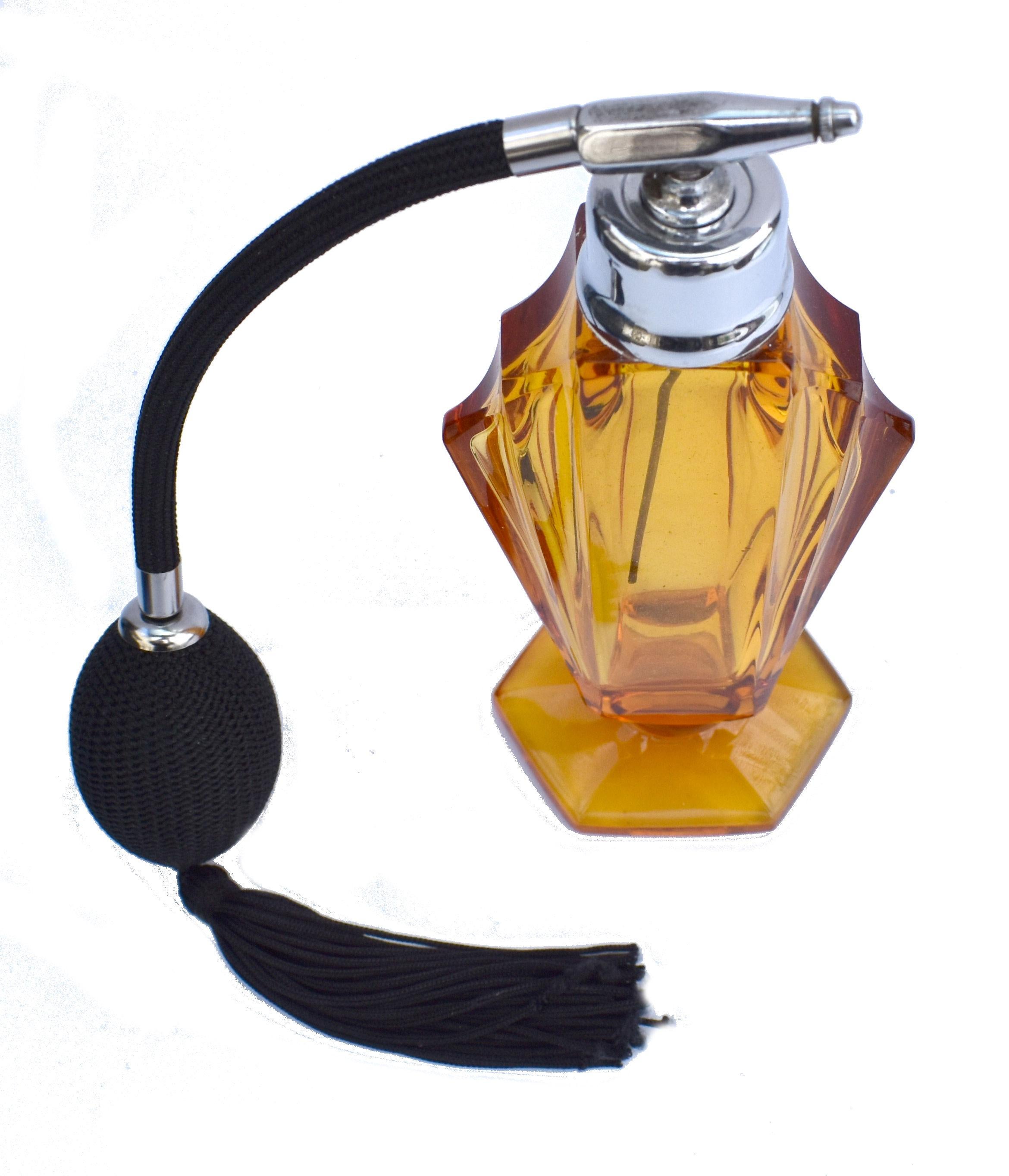 This fabulous Art Deco perfume atomiser is an absolute delight. Large glass body with multi angled edges is in a beautiful amber color with black silk bulb and tassel and chrome fittings. Much larger in size than normal so has a real presence about