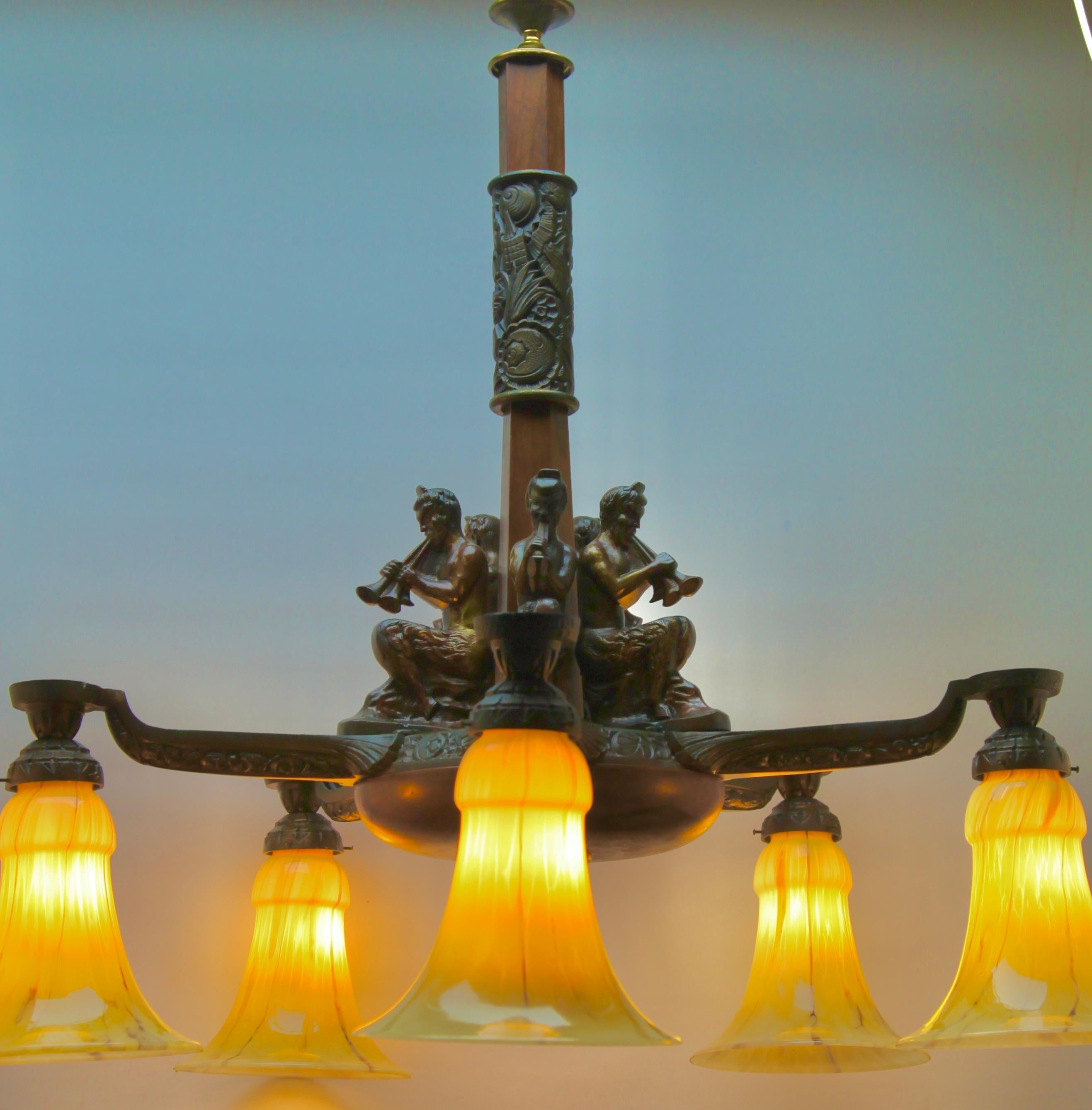 Art Deco chandelier pendant on chain with five mounts of solid Bronze, 
unusual glass lampshades.

Completely restored 
With original patina on brass and wooden parts.

Total weight 17.9 KG / 39.46 Pounds

In good condition and in full