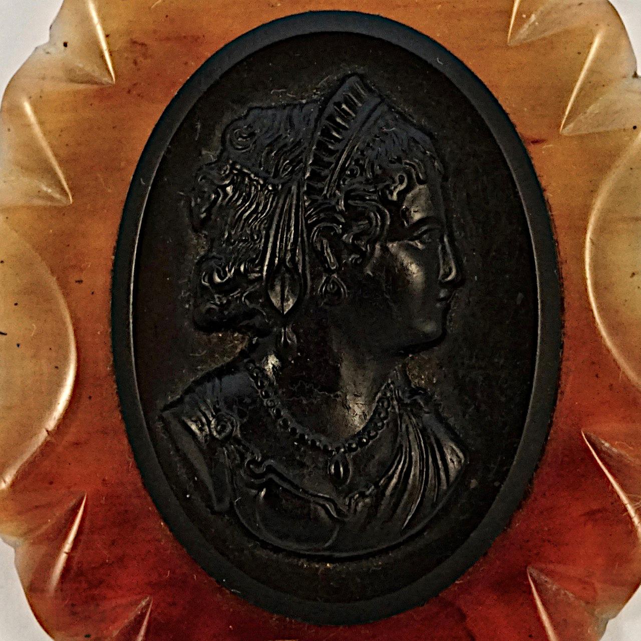 Beautiful large oval black and amber early plastic cameo brooch. Measuring 7 cm / 2.75 inches by 5.5 cm / 2.1 inches. There is scratching as expected and wear to the back. The fastening has some rust.

This wonderful statement cameo brooch is circa