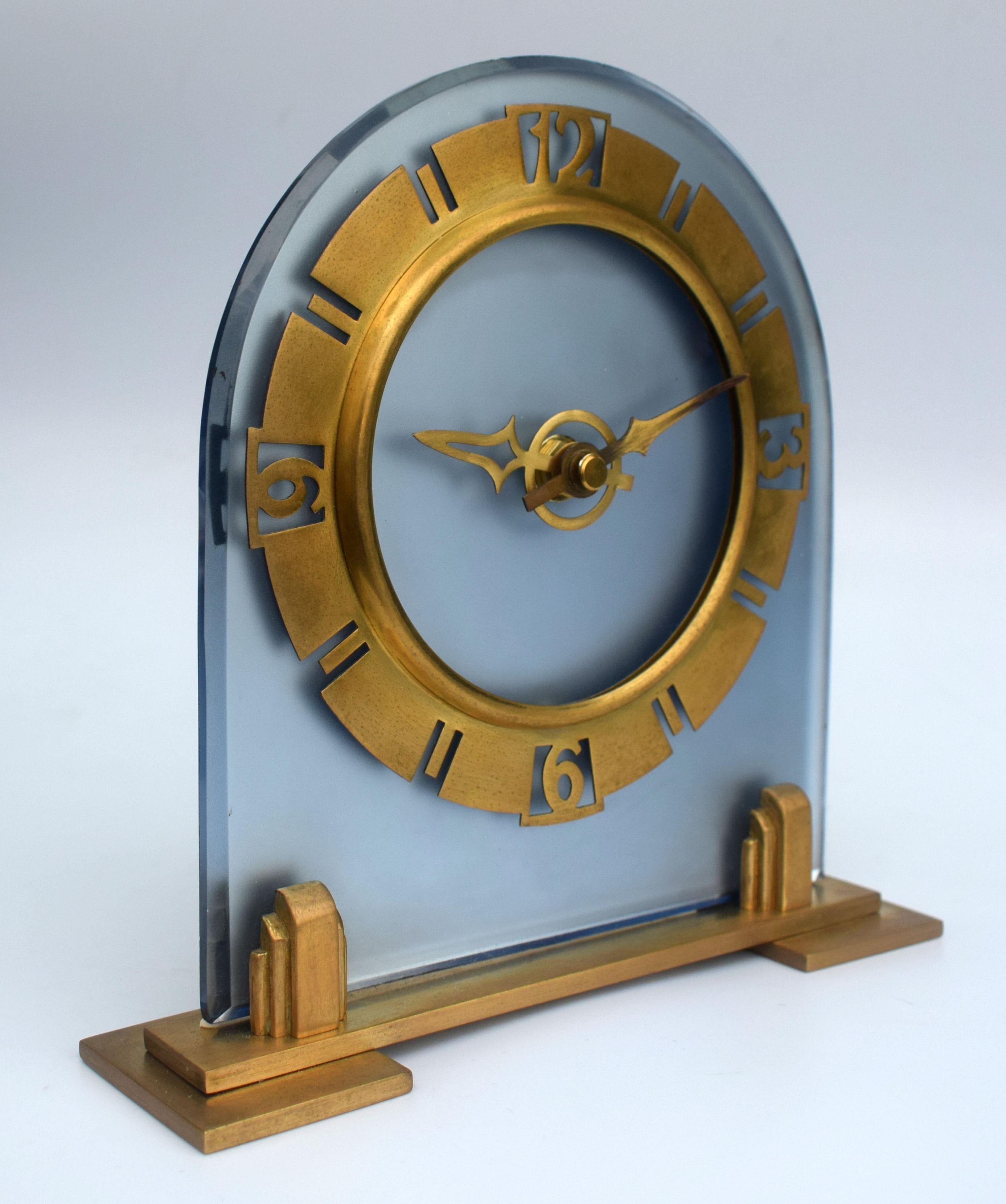 Very attractive and glamorous 1930s Art Deco frosted blue glass clock. Replacement quartz battery movement from electrical, so no plugs or winding required. Features a heavy thick blue mirror glass face with brass Bezel and plinth. The condition is
