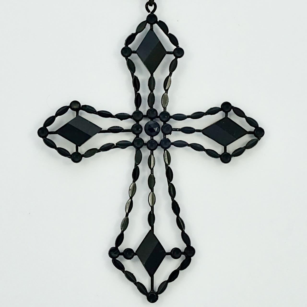Pendentif croix Art Déco en jais français, avec une chaîne de perles de verre noires. Ce magnifique pendentif comporte des pièces de jais français facettées. Chaque pièce est dans une monture émaillée noire et appliquée sur un fil émaillé. Longueur