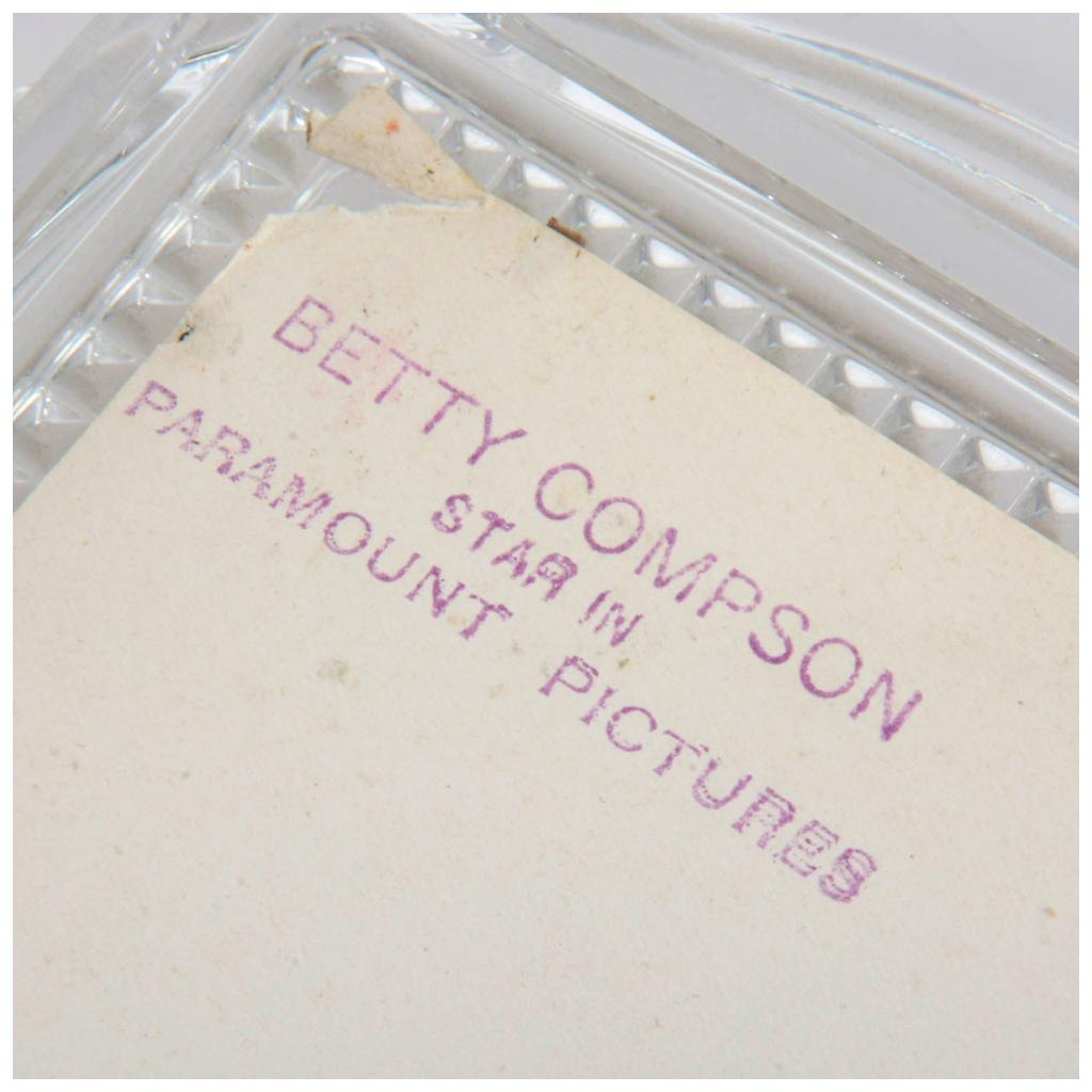 An Art Deco cut lead glass photo frame. The glass shows faceted decorations and a silverplate back with easel stand. The frame's glass part is in excellent condition.

The back includes the Betty Compson photograph. The picture has the Famous